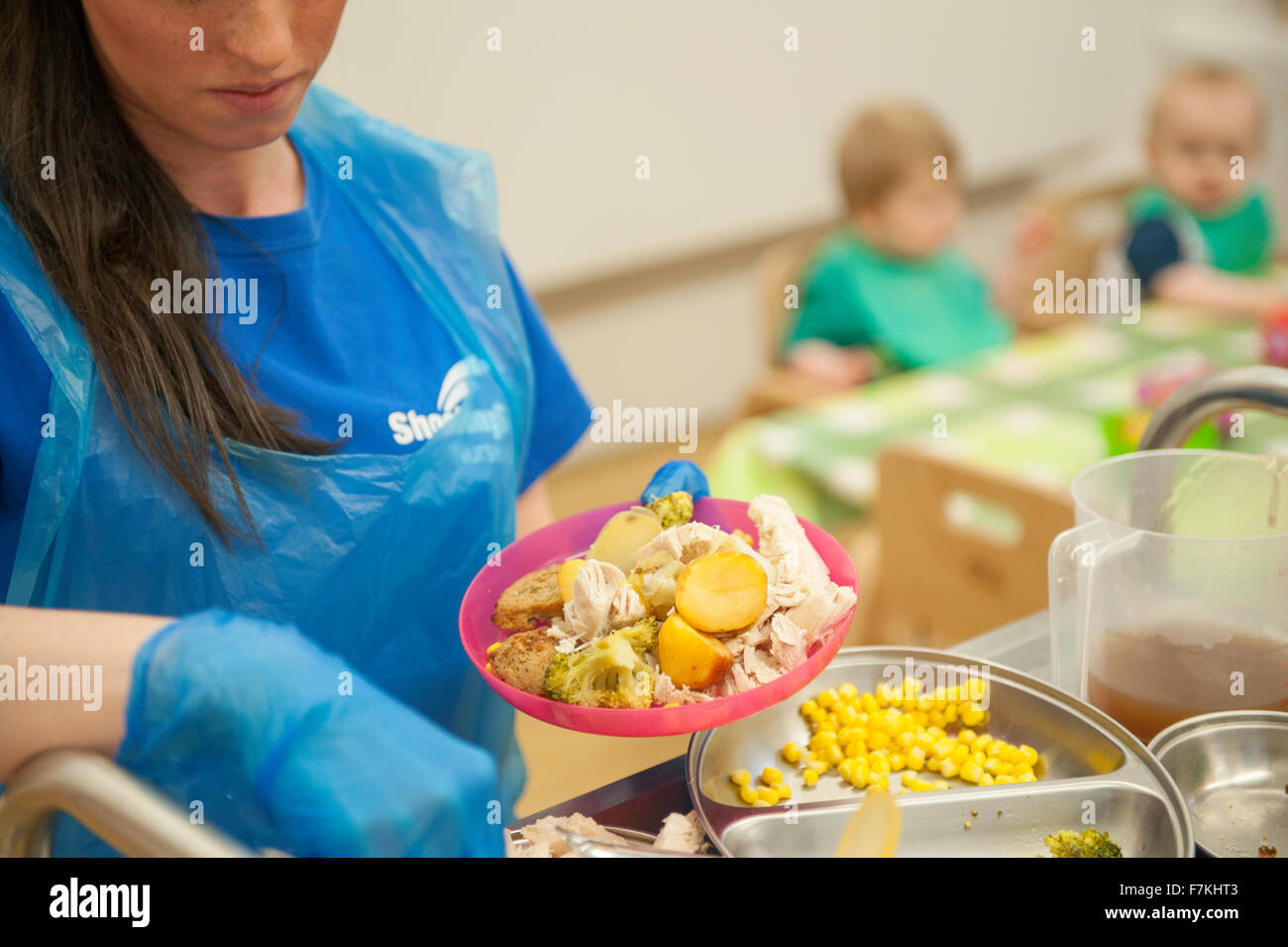 Un lavoratore di vivaio preparare un pasto per bambini Foto Stock