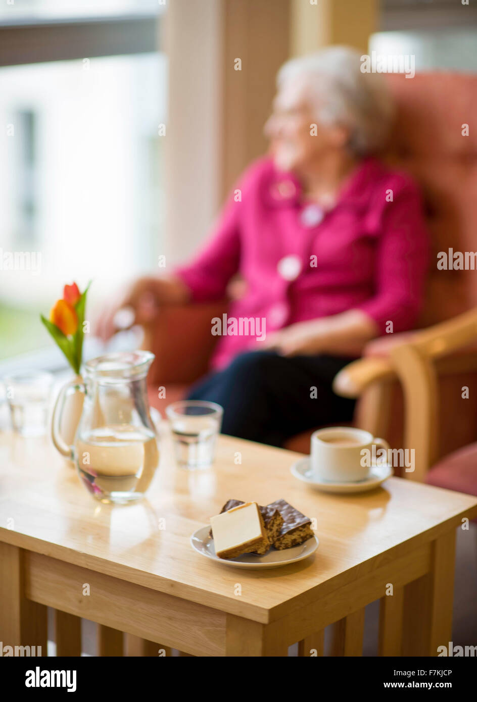 Una vecchia signora avente una tazza di tè in un vecchio folks home Foto Stock