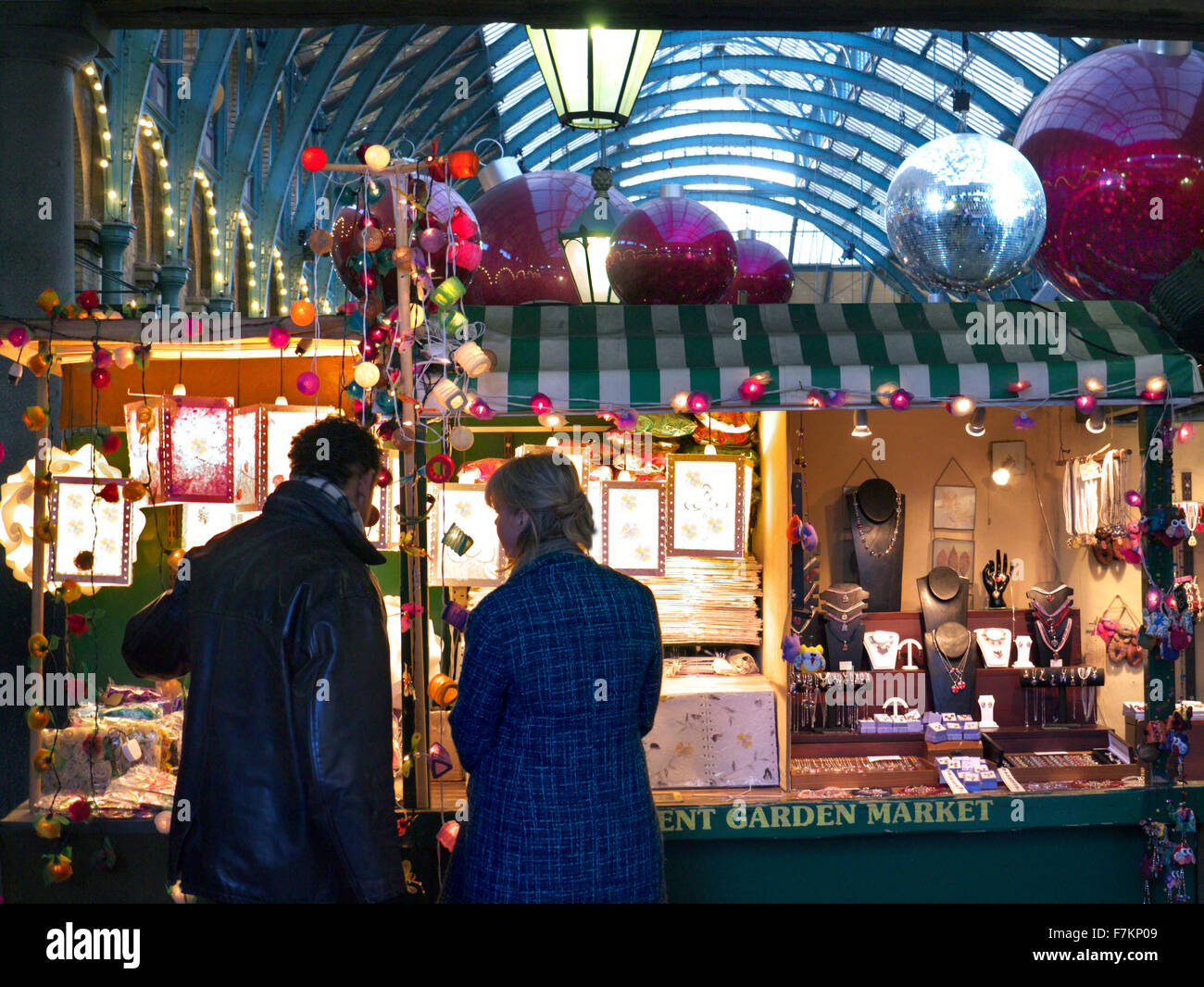 Il mercato di Apple Hall e gli acquirenti di Natale al mercato di Covent Garden stallo con decorazioni di Natale London REGNO UNITO Foto Stock
