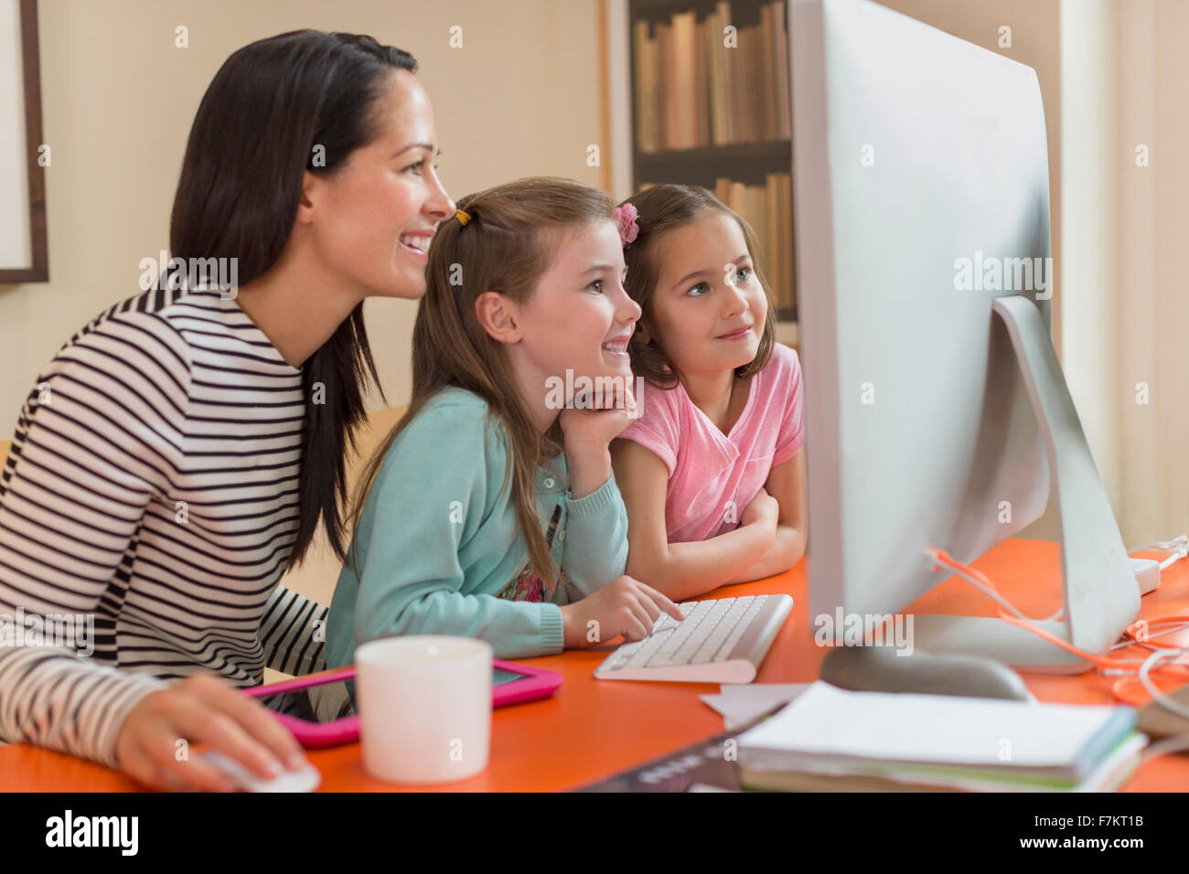 La madre e le figlie tramite il computer Foto Stock