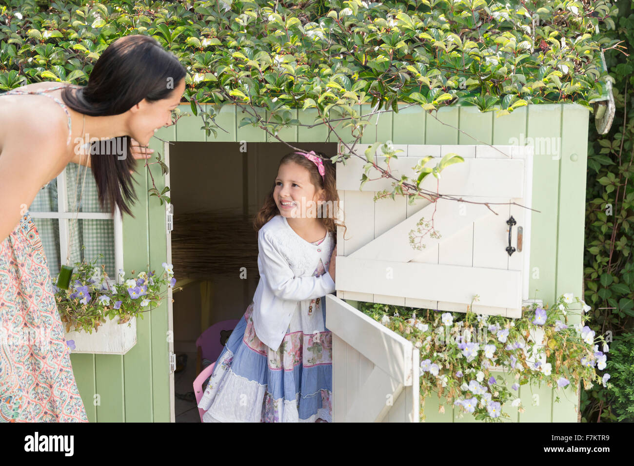 Madre e figlia al playhouse in giardino Foto Stock