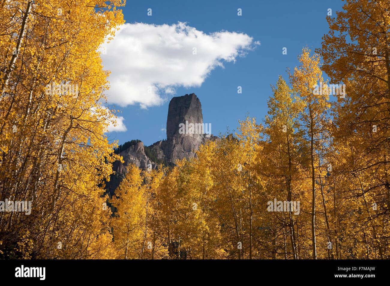 Picco di camino con il bianco puffy nuvole che mostra Courthouse Mountain nel Uncompahgre National Forest, Colorado Foto Stock