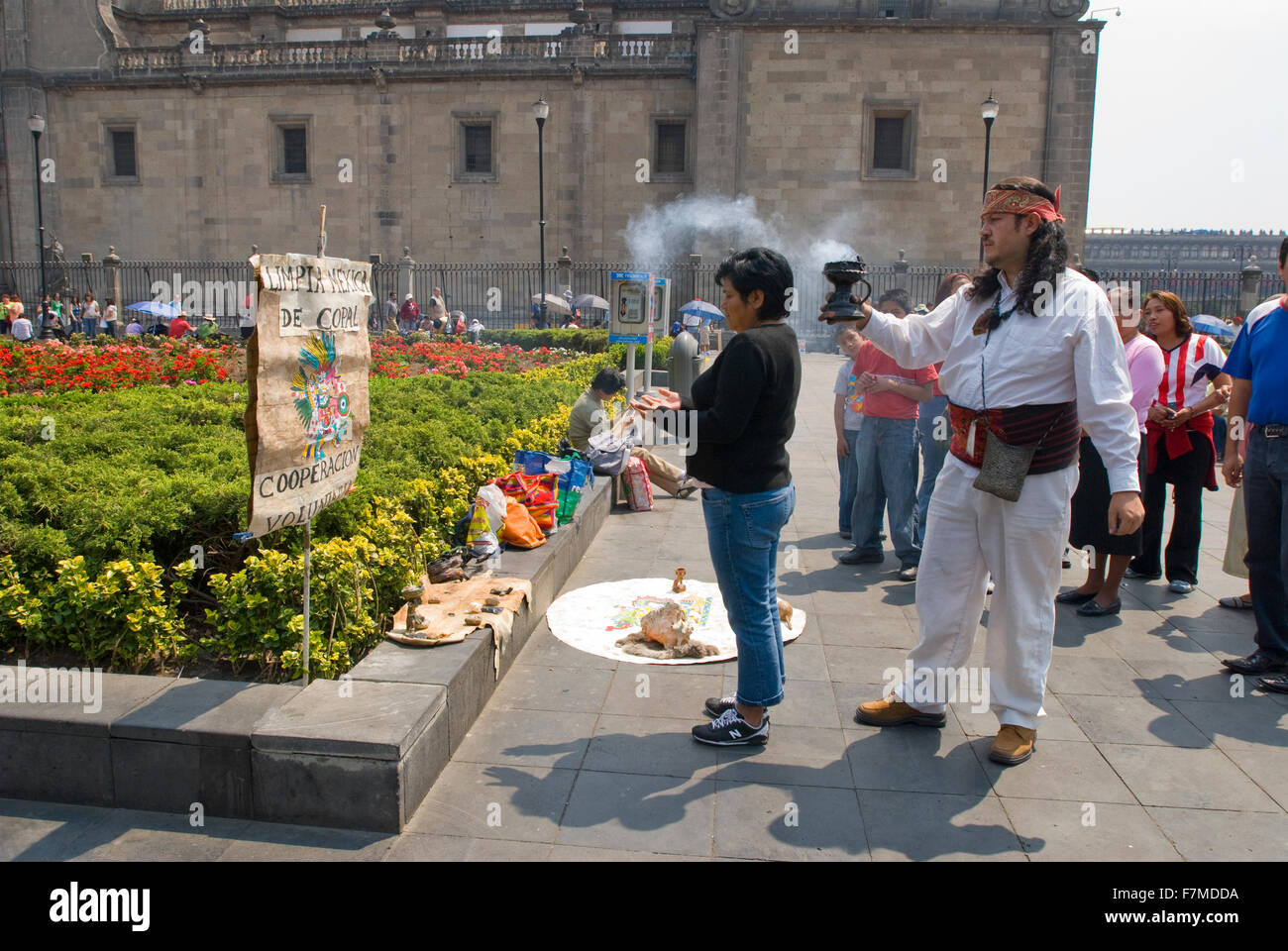 Sciamano messicano di eseguire una cerimonia di pulizia su una donna nel Zocalo, Città del Messico. La masterizzazione di resina copale Foto Stock