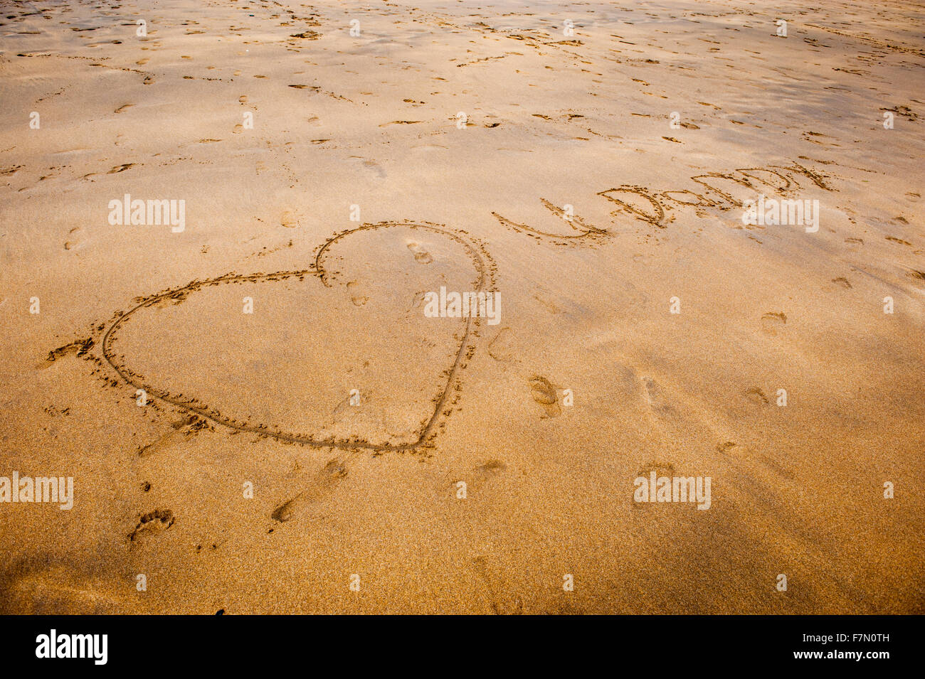 Forma di cuore disegnato nella sabbia sulla spiaggia Foto Stock