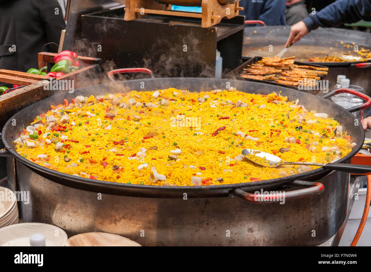 La paella piatto di riso in una grande pentola di cottura al mercato Foto Stock