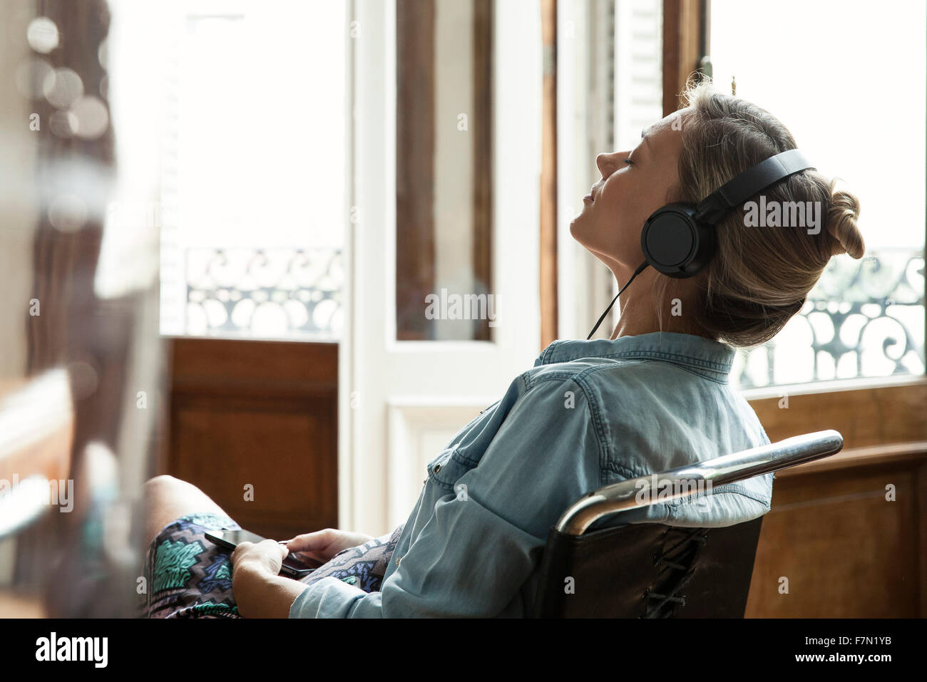 Donna rilassante mentre si ascolta la musica Foto Stock