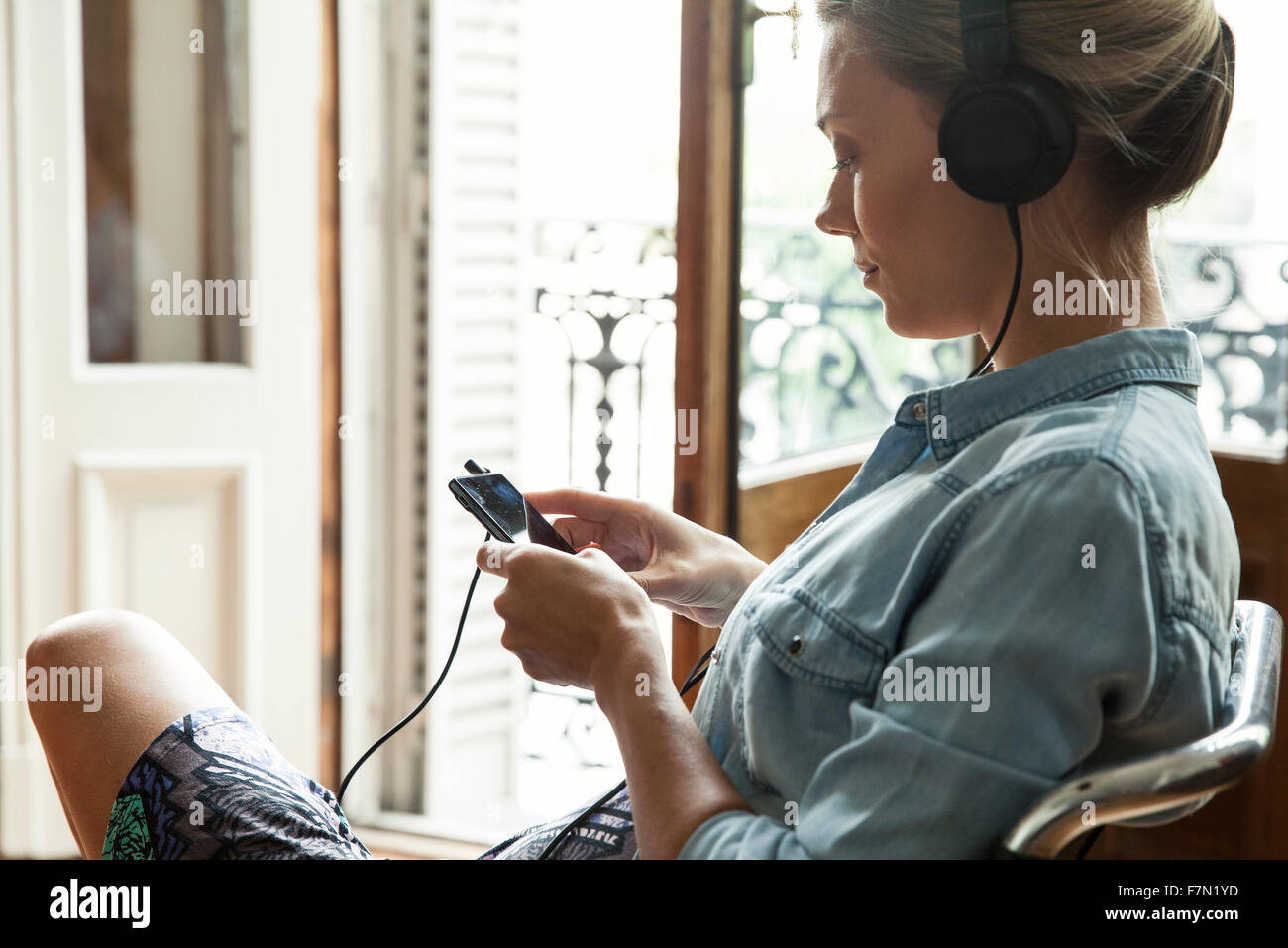 Donna ascoltando musica in riproduzione sullo smartphone Foto Stock