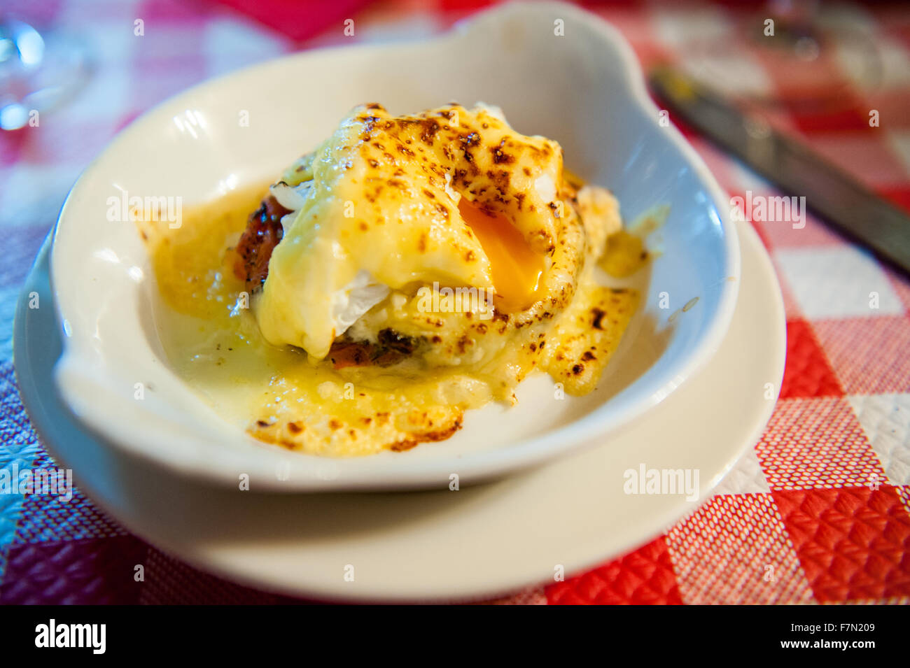 Uovo affogato piatto in un piatto su un rosso tovaglia Foto Stock