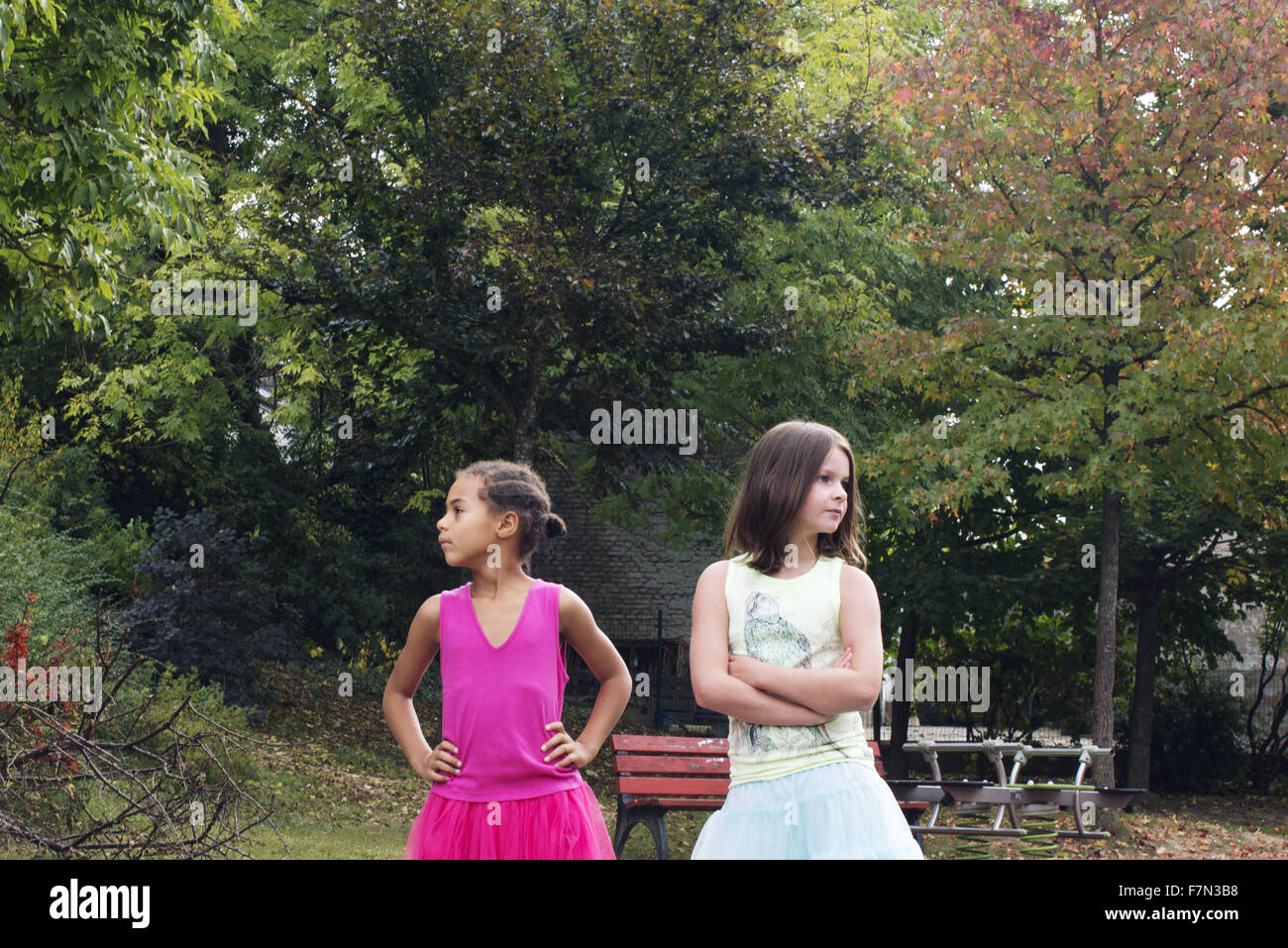 Le ragazze in piedi insieme all'aperto, entrambi guardando lontano rabbiosamente Foto Stock