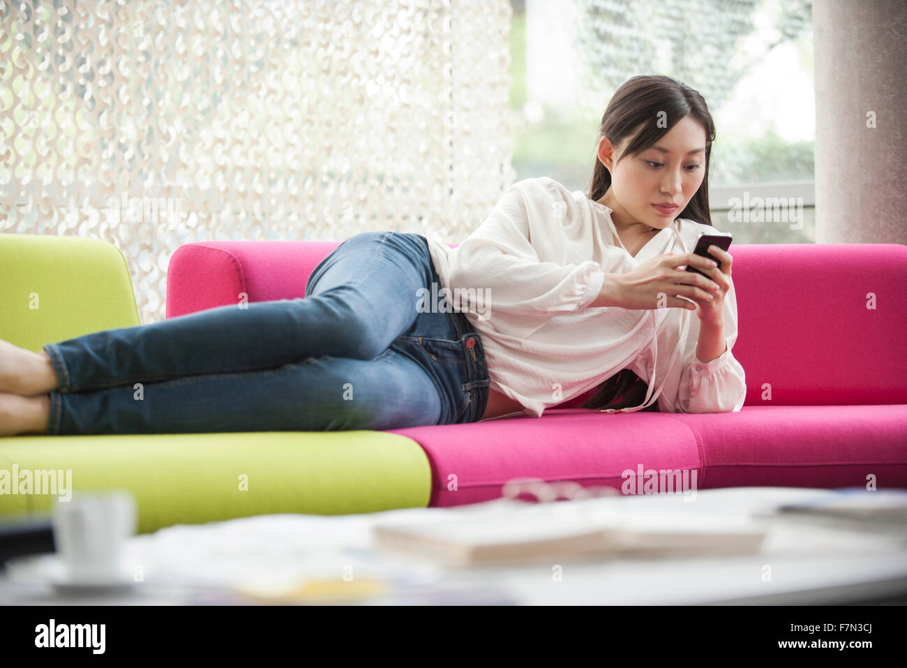 La donna in un momento di relax a casa con lo smartphone Foto Stock