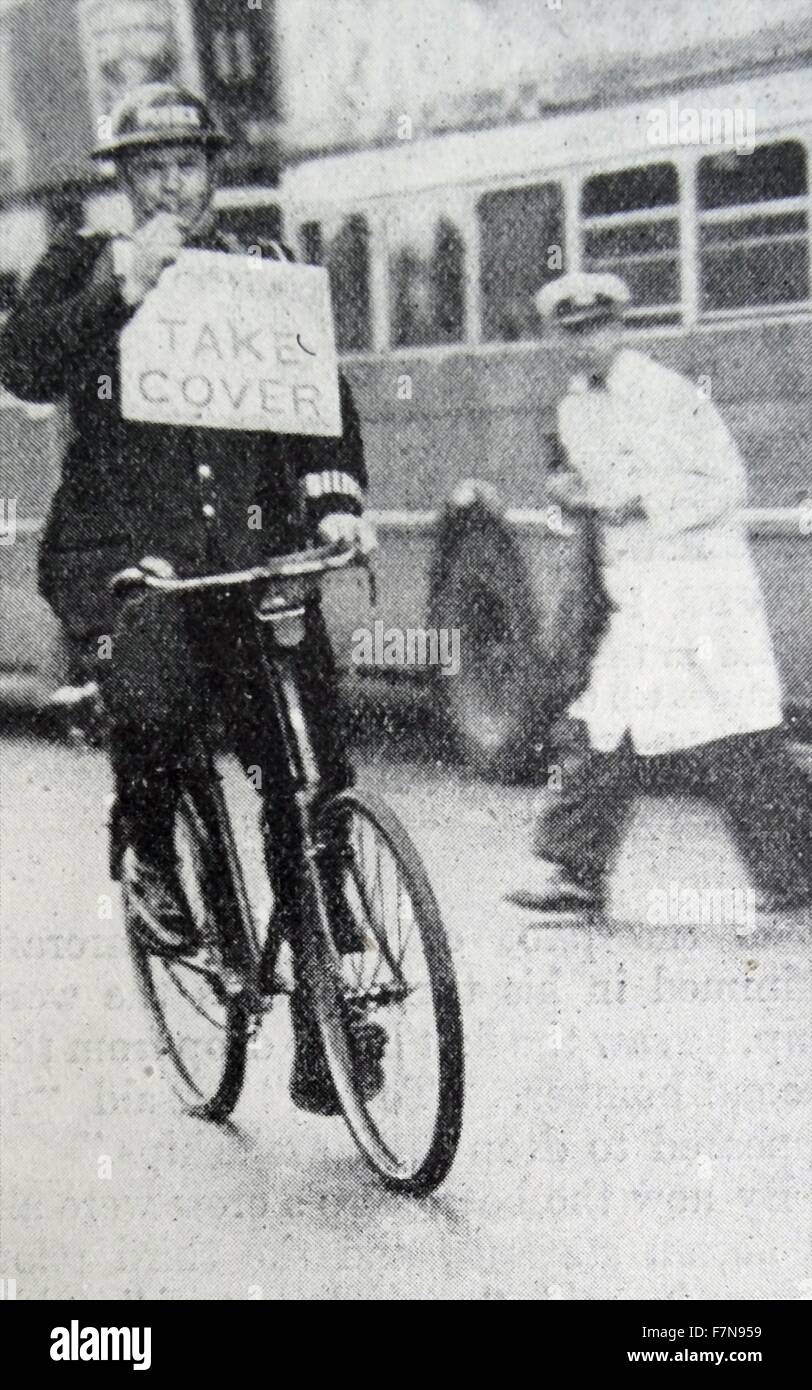 Fotografia di un poliziotto avviso di persone a prendere la copertura dopo le sirene suonavano. Lo stesso sistema è stato usato durante le incursioni nella Prima Guerra Mondiale. Datata 1939 Foto Stock