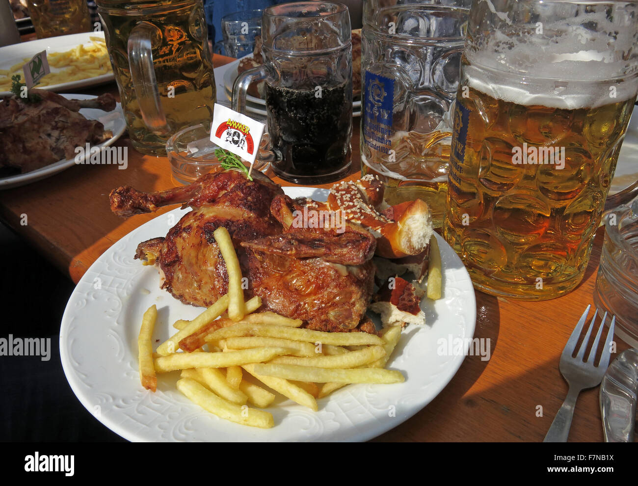 Oktoberfest beer steins festival e cibo, mezzo pollo e patatine fritte, Monaco di Baviera, Germania Foto Stock