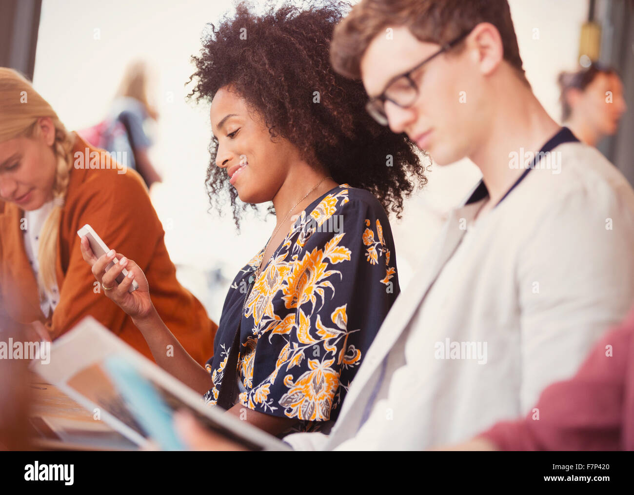 Donna sorridente texting con un telefono cellulare in cafe Foto Stock