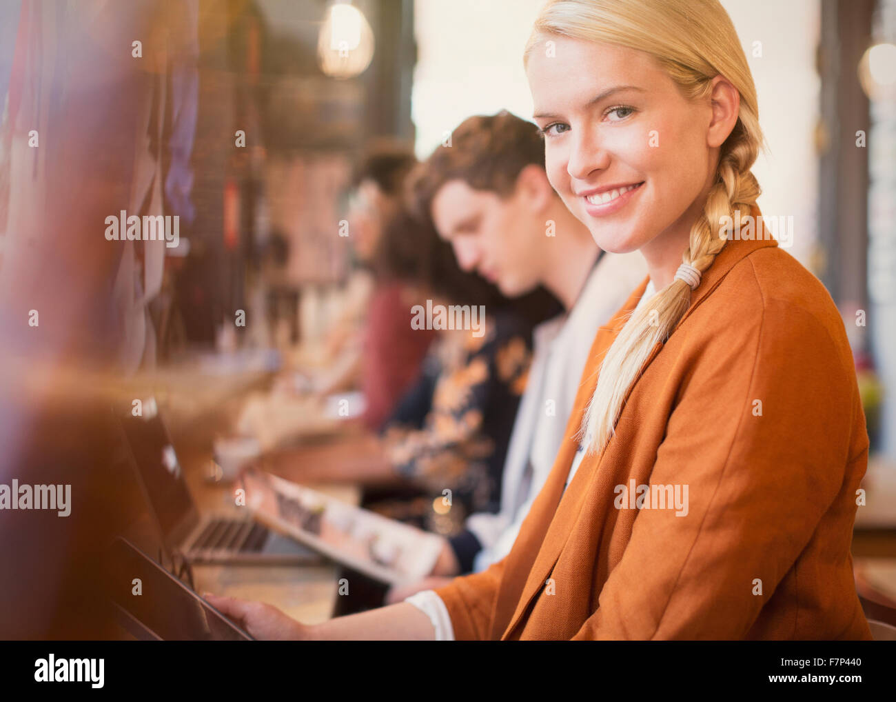 Ritratto sorridente donna bionda con tavoletta digitale in cafe Foto Stock