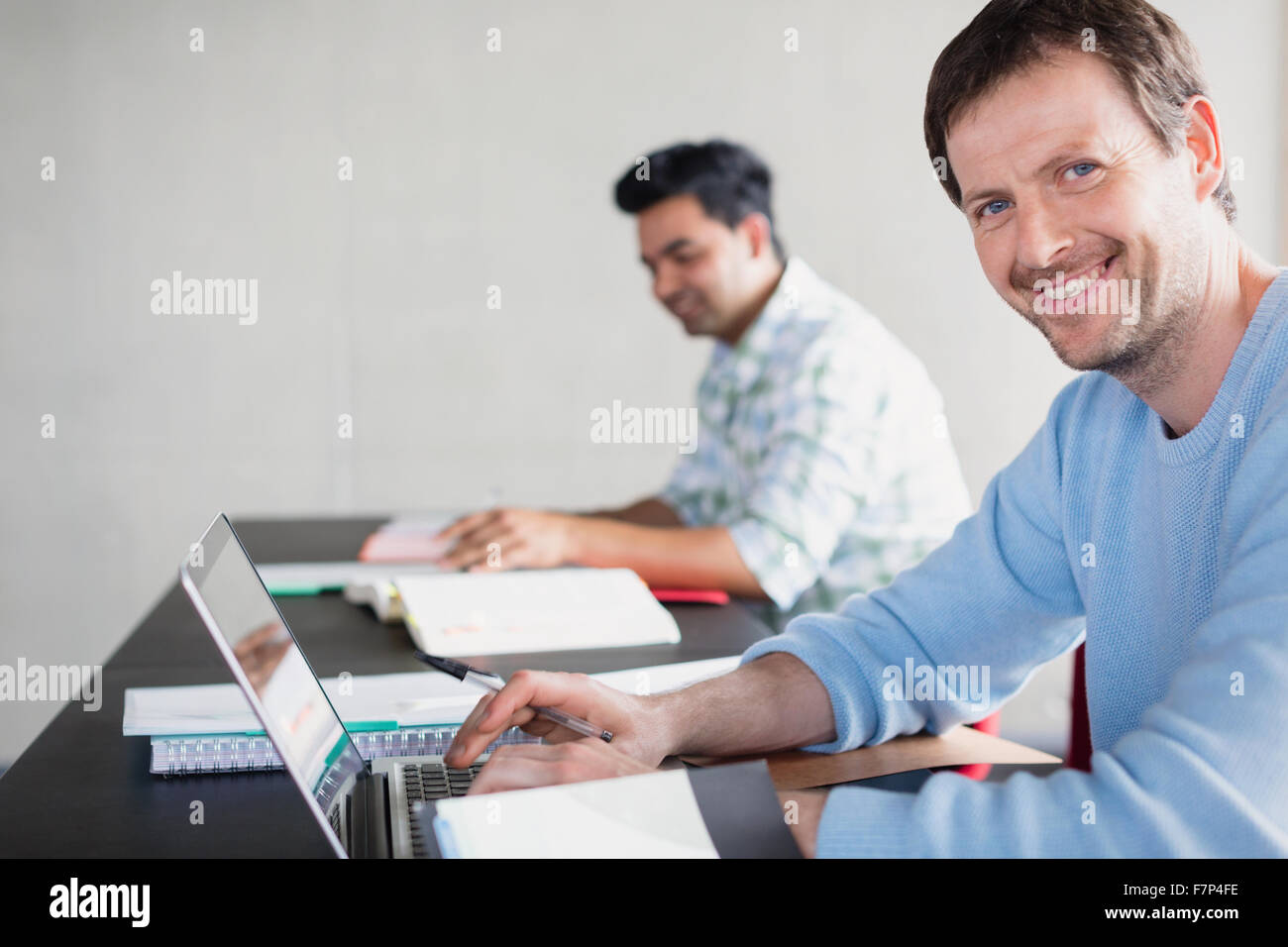 Ritratto fiducioso uomo al laptop di educazione degli adulti classroom Foto Stock