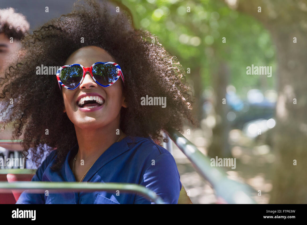 Donna entusiasta con Afro indossa il cuore gli occhiali di forma Foto Stock