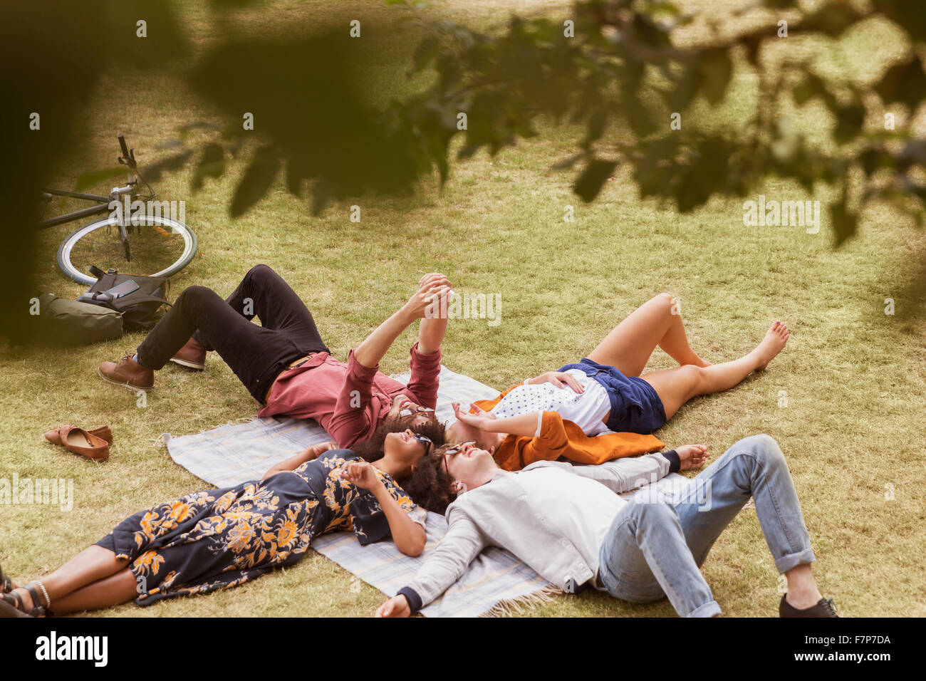 Amici prendendo selfie posa in cerchio su una coperta in posizione di parcheggio Foto Stock