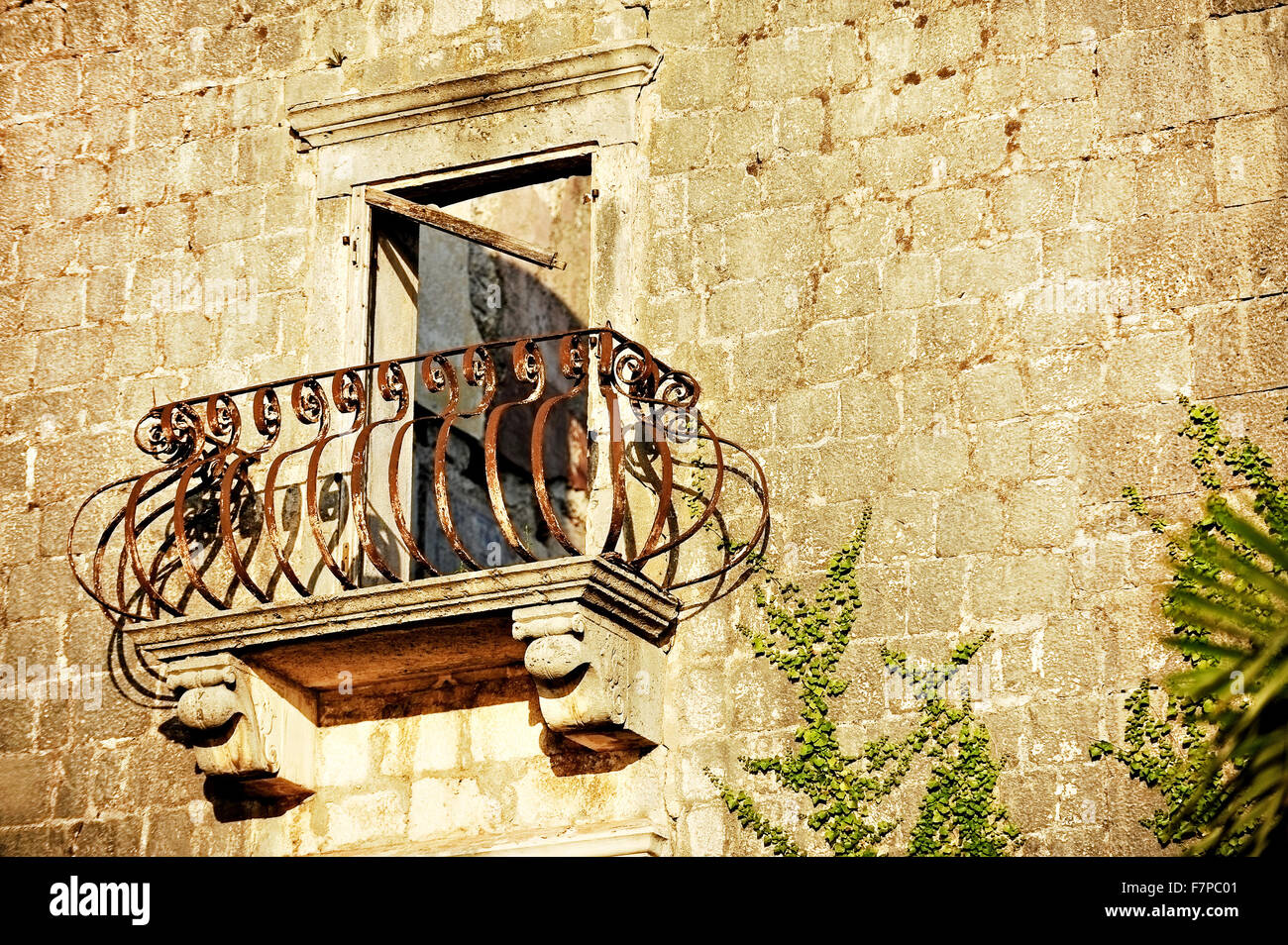 Architettura dettaglio con un arrugginito ferro battuto balcone sulla facciata di una casa abbandonata Foto Stock