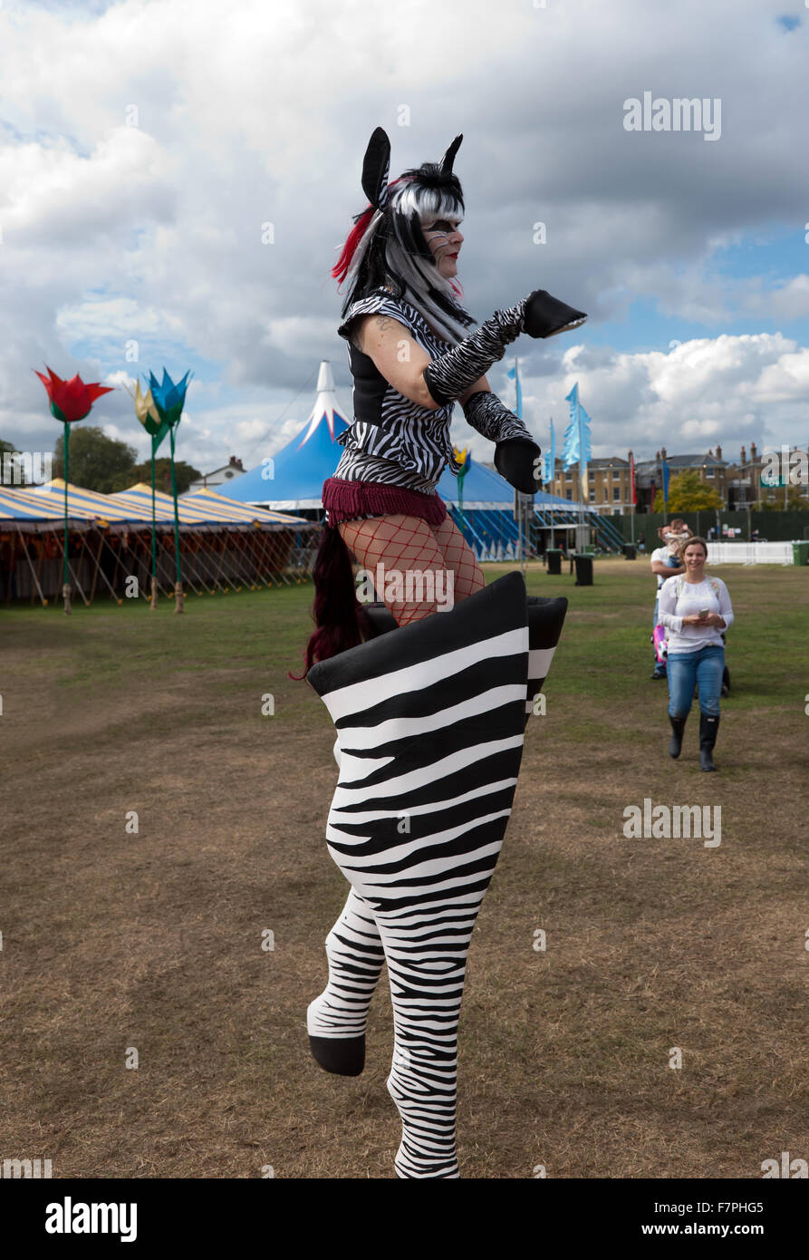 Un roaming performing artist vestito come un 'Zebra Donna", intrattiene la folla al di Blackheath Music Festival Foto Stock