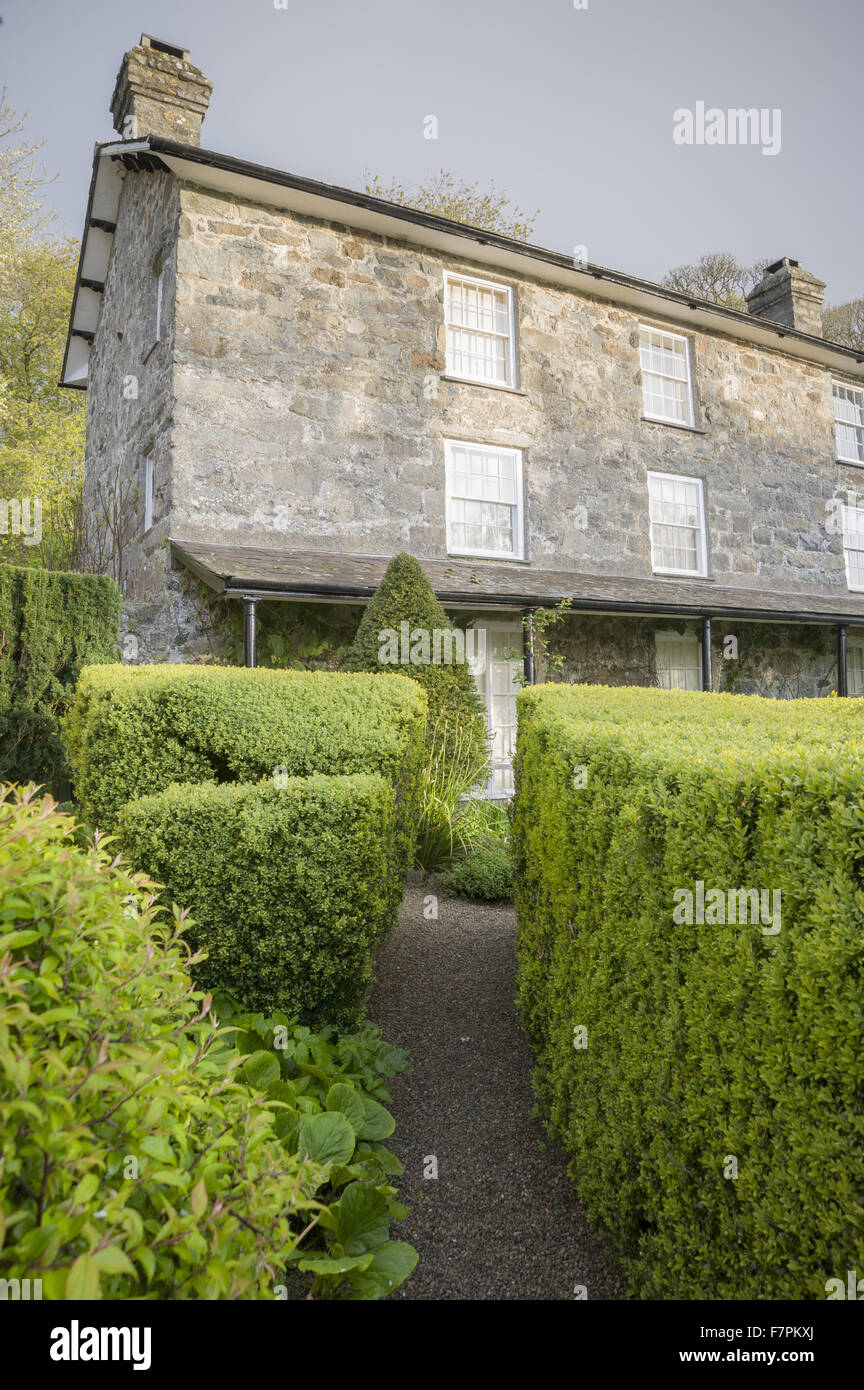 Il lato sud della casa, mostrando una veranda, siepi di bosso e agganciata yew topiaria da a Plas yn Rhiw, Gwynedd. I giardini di Plas yn Rhiw hanno viste spettacolari su Cardigan Bay. Foto Stock