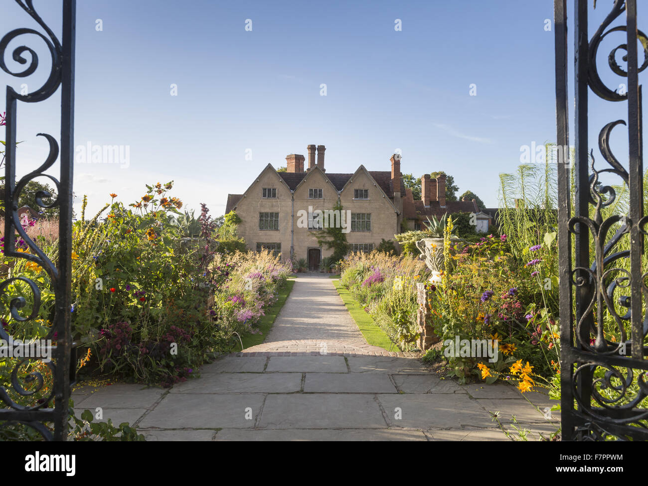 La casa si vede attraverso i cancelli aperti a Packwood House, Warwickshire. Packwood House ha origini giacciono nel XVI secolo, ma è stato ampiamente restaurato nel 1920s. Foto Stock