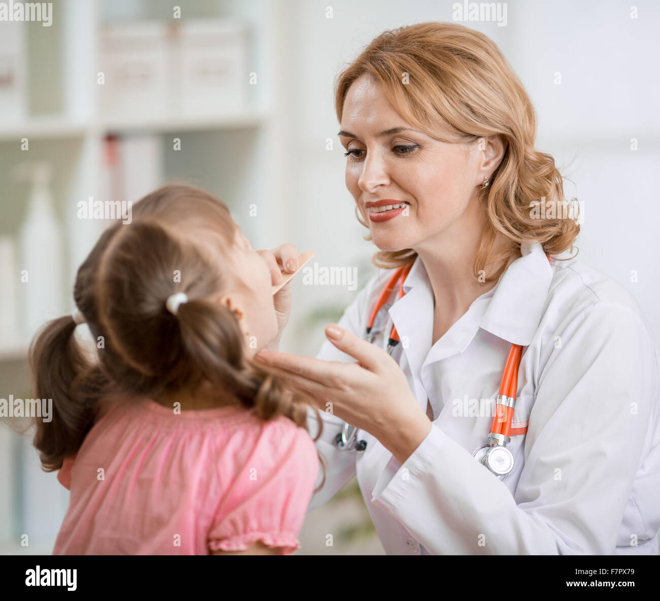 Medico pediatra esaminando kid's gola Foto Stock