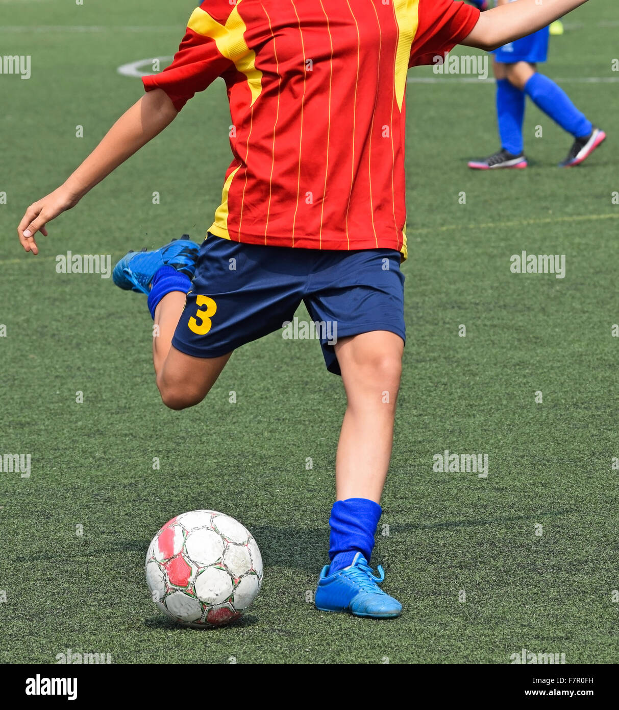Giovane giocatore di calcio calci la palla Foto Stock