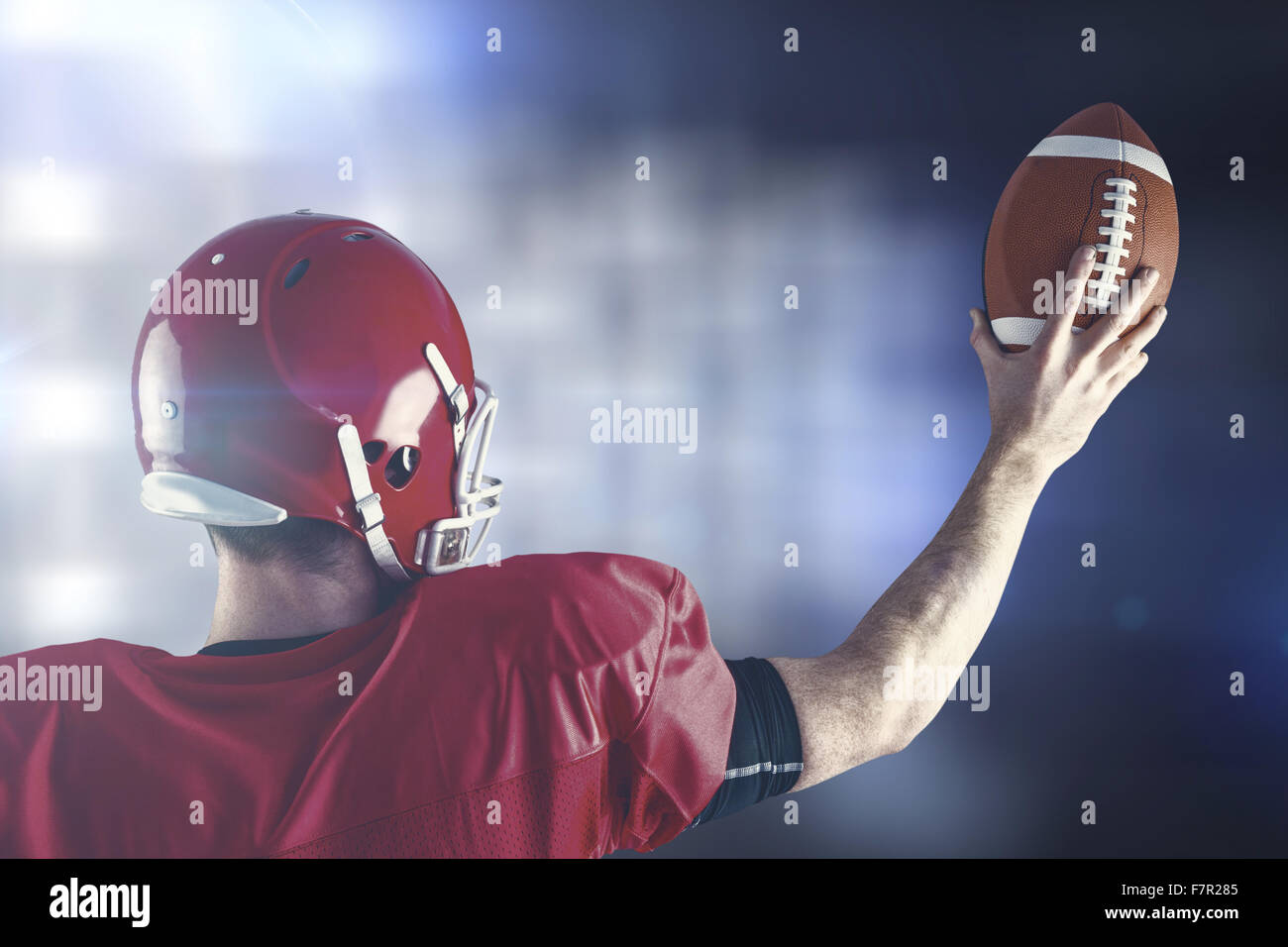 Immagine composita della vista posteriore del giocatore di football americano tenendo alto il calcio Foto Stock