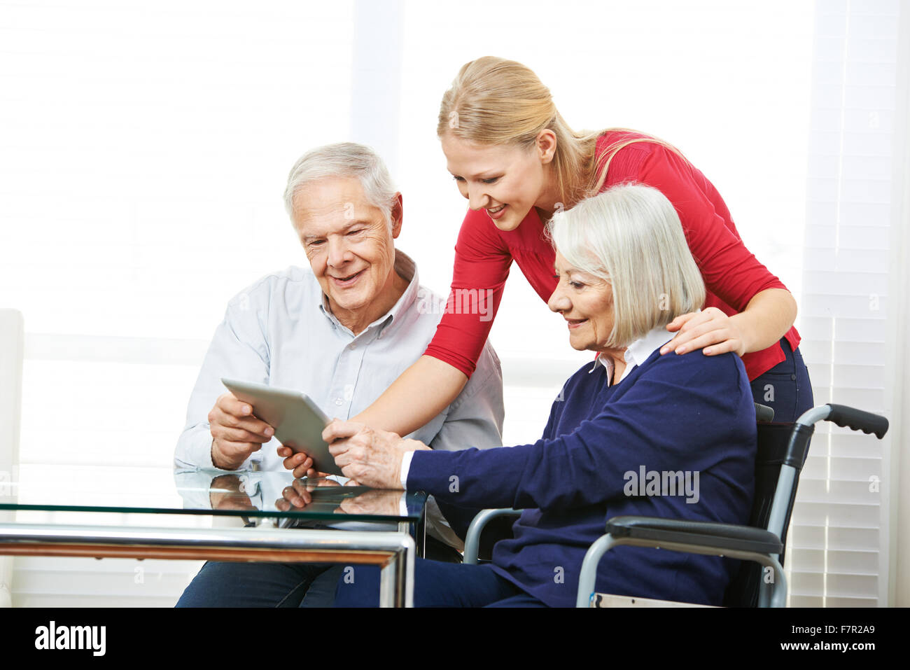 Felice coppia senior per imparare a usare il computer tablet con il nipote Foto Stock