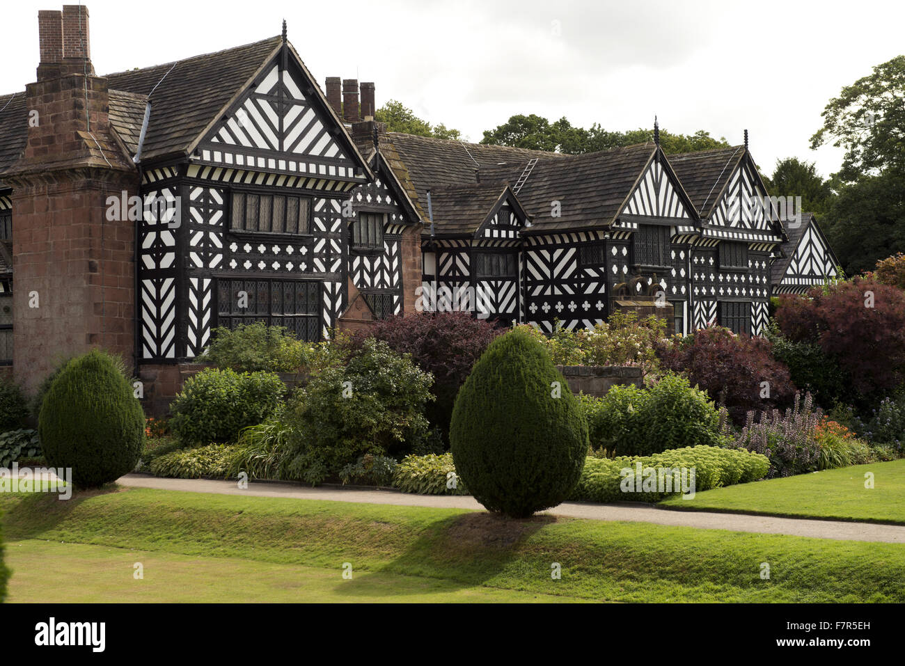Speke Hall, giardino e station wagon, Merseyside. Speke Hall è un Tudor Manor House con interni in stile vittoriano, compresi originale di William Morris sfondo. Foto Stock