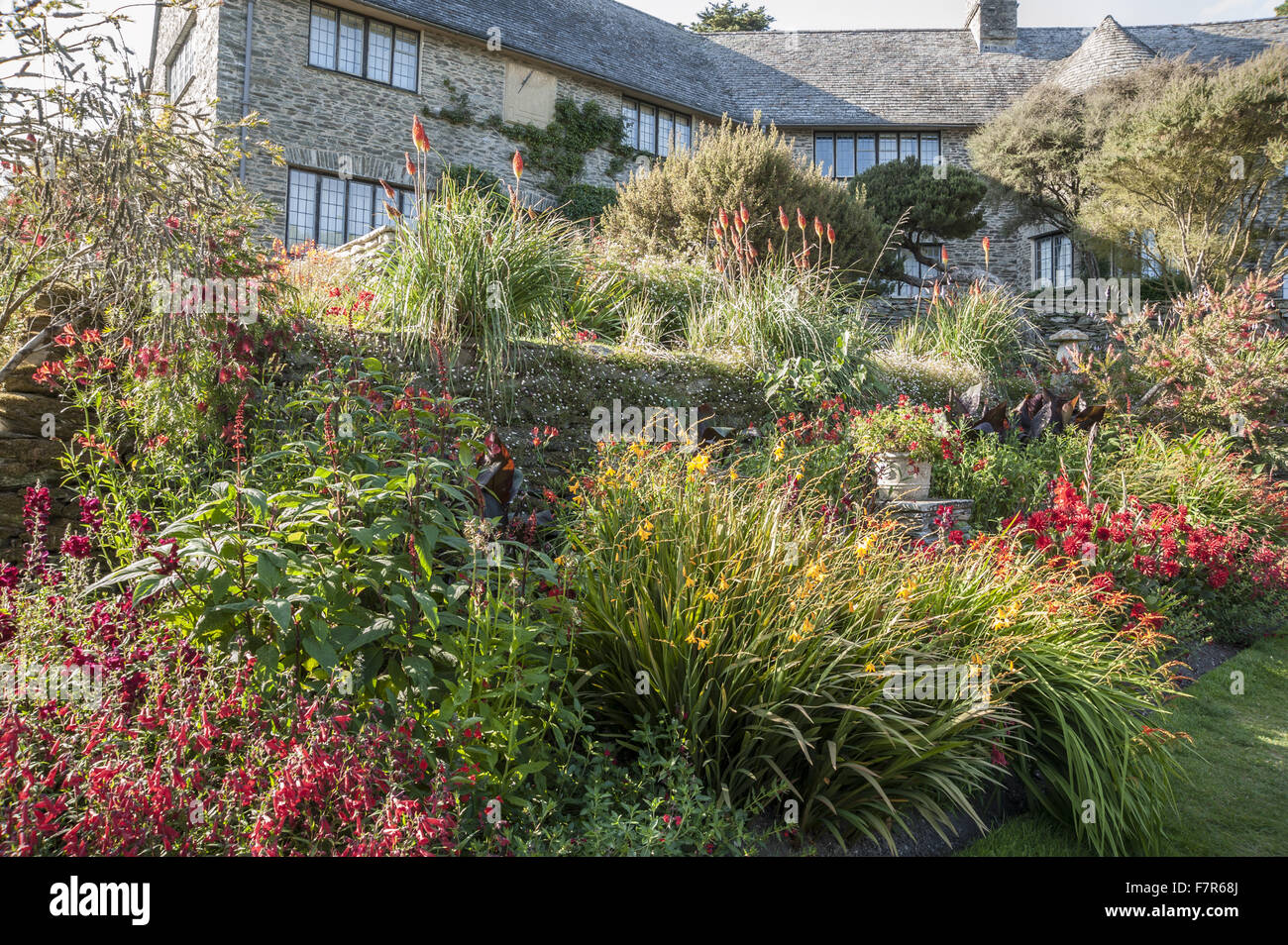 Confine sotto la casa in corrispondenza Coleton Fishacre, Devon. Piante includono crocosmias, dalie, gladioli, salvia confertiflora, penstemons e red hot mazze. Foto Stock