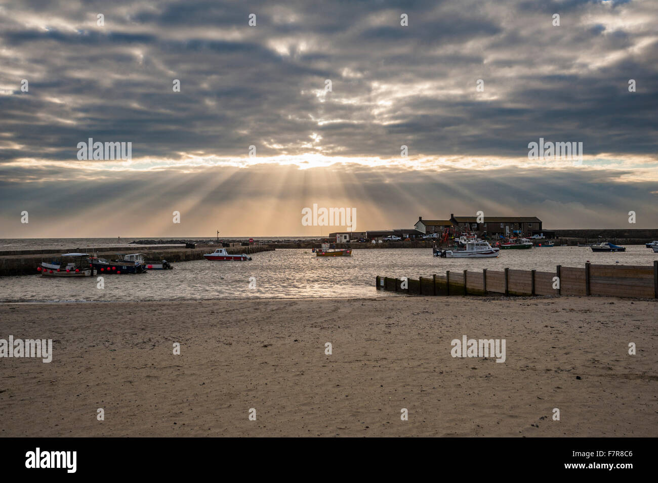 Il porto di Cobb, Lyme Regis, Dorset, Regno Unito. 2 Dicembre 2015 - fasci di luce del sole che splende attraverso le nuvole sopra lo storico porto di Cobb a Lyme Regis. Immagine: Graham Hunt/Alamy Live News Foto Stock