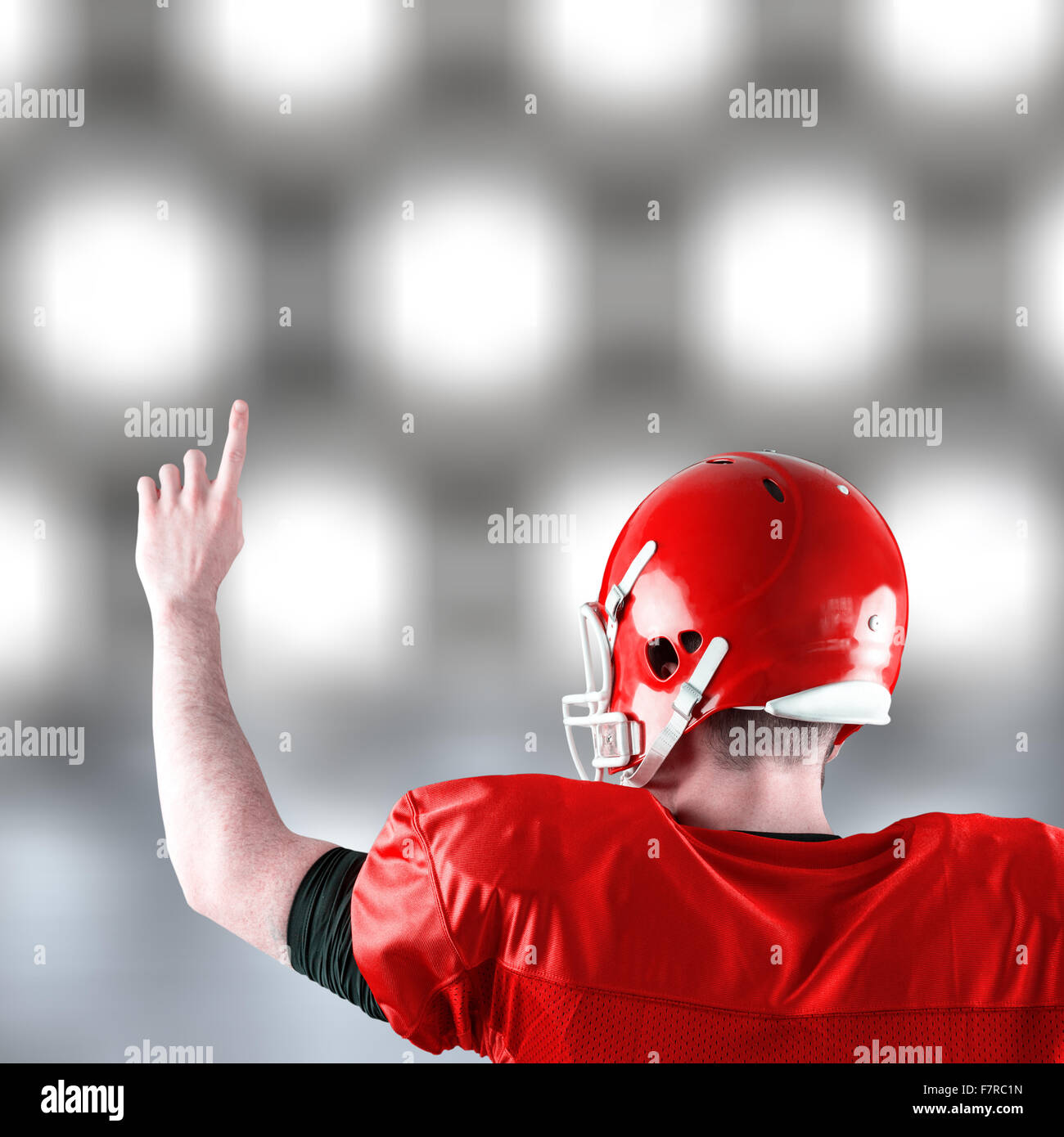 Immagine composita della vista posteriore del giocatore di football americano in trionfo Foto Stock