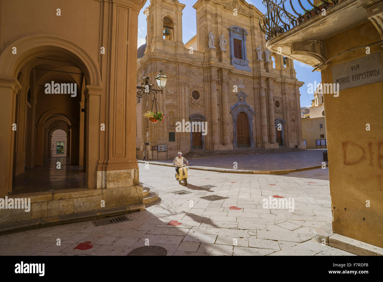 Sicilia barocca, vista di un uomo siciliano in sella al suo scooter attraverso l'ambiente barocco di Piazza della Repubblica a Marsala, Sicilia. Foto Stock