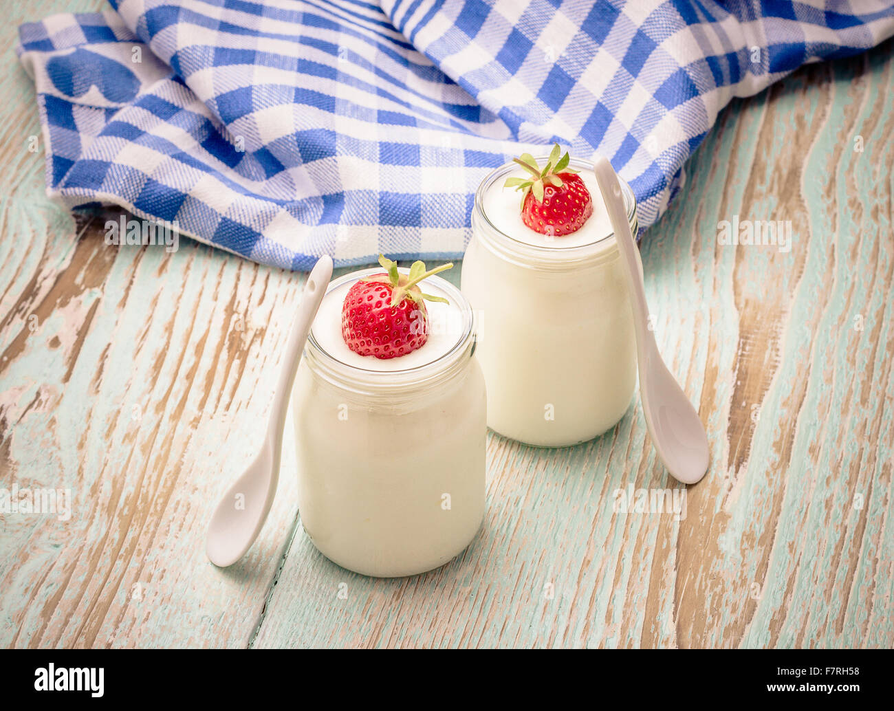 Yogurt Greco, di vetro con le fragole e il cucchiaio in ceramica Foto Stock
