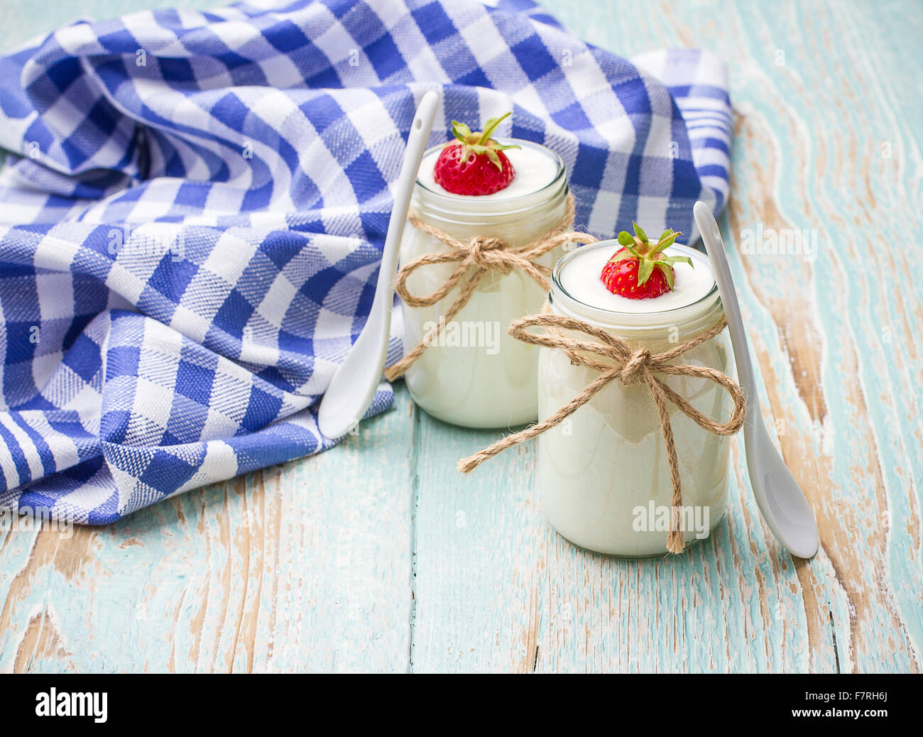 Yogurt Greco, di vetro con le fragole e il cucchiaio in ceramica Foto Stock