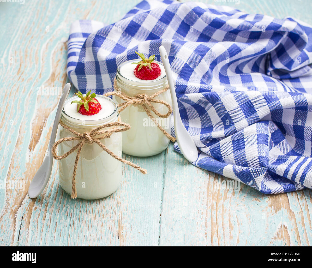 Yogurt Greco, di vetro con le fragole e il cucchiaio in ceramica Foto Stock