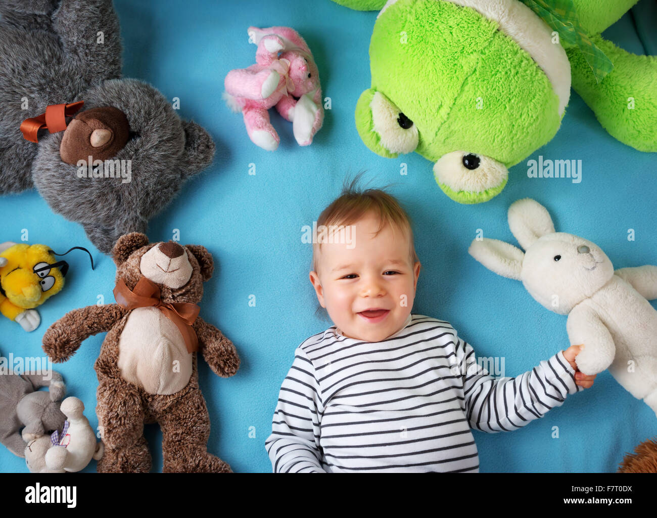 Felice anno vecchio ragazzo disteso con molti giocattoli di peluche Foto Stock