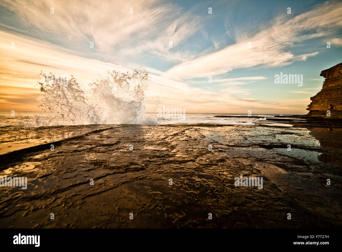 Forme d'onda colpendo la riva nella luce del mattino sotto il Scillion, Terrigal / Australia Foto Stock