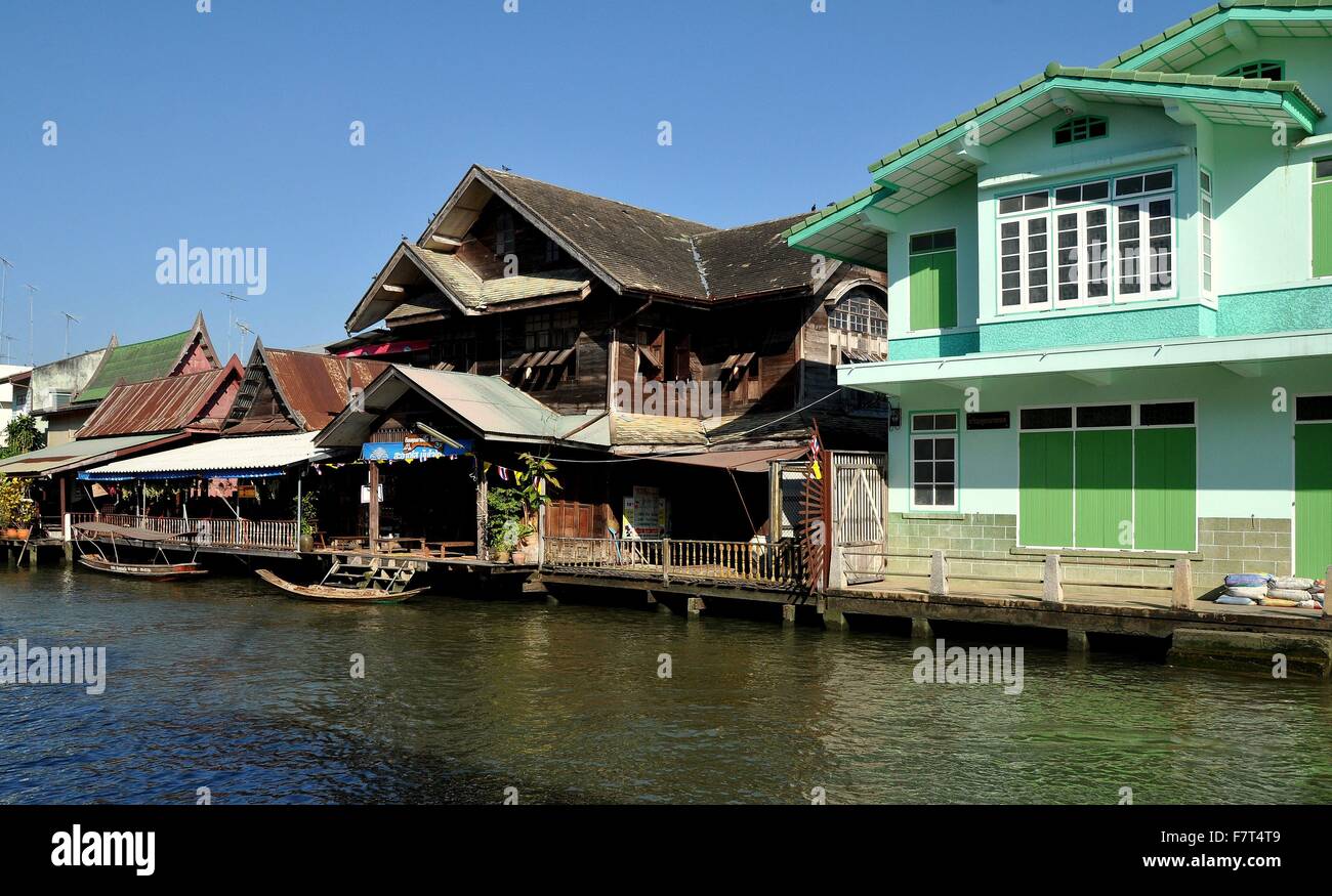 Amphawa, Thailandia: vecchie case in legno ondulato con tetti di stagno linea il Mae Klong canal al mercato galleggiante di Amphawa Foto Stock