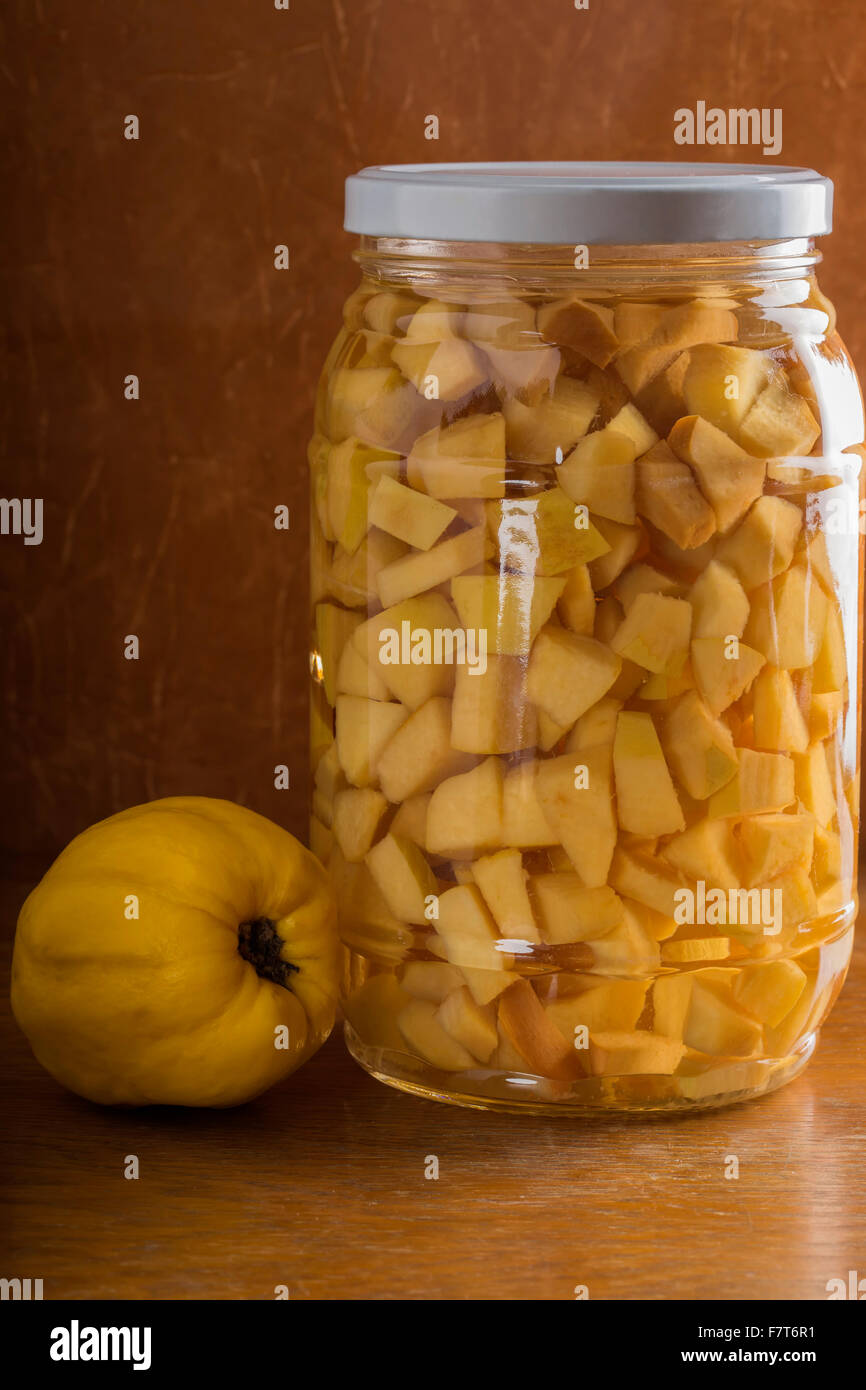 Deliziosi dolci composta di mela cotogna in vaso su un tavolo di legno Foto Stock