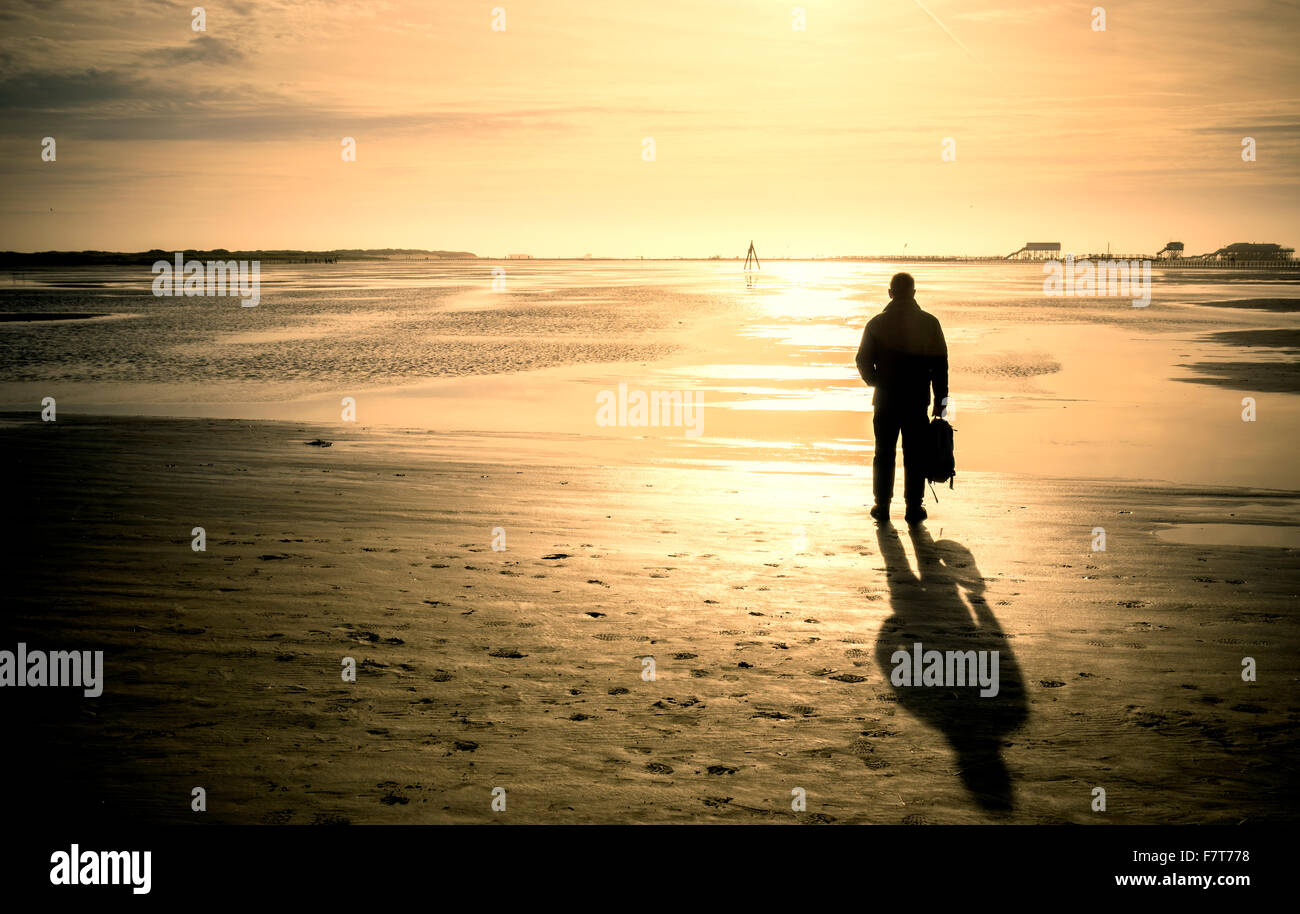 Walker sulla spiaggia al tramonto, Sankt Peter-Ording, Schleswig Holstein, Germania Foto Stock