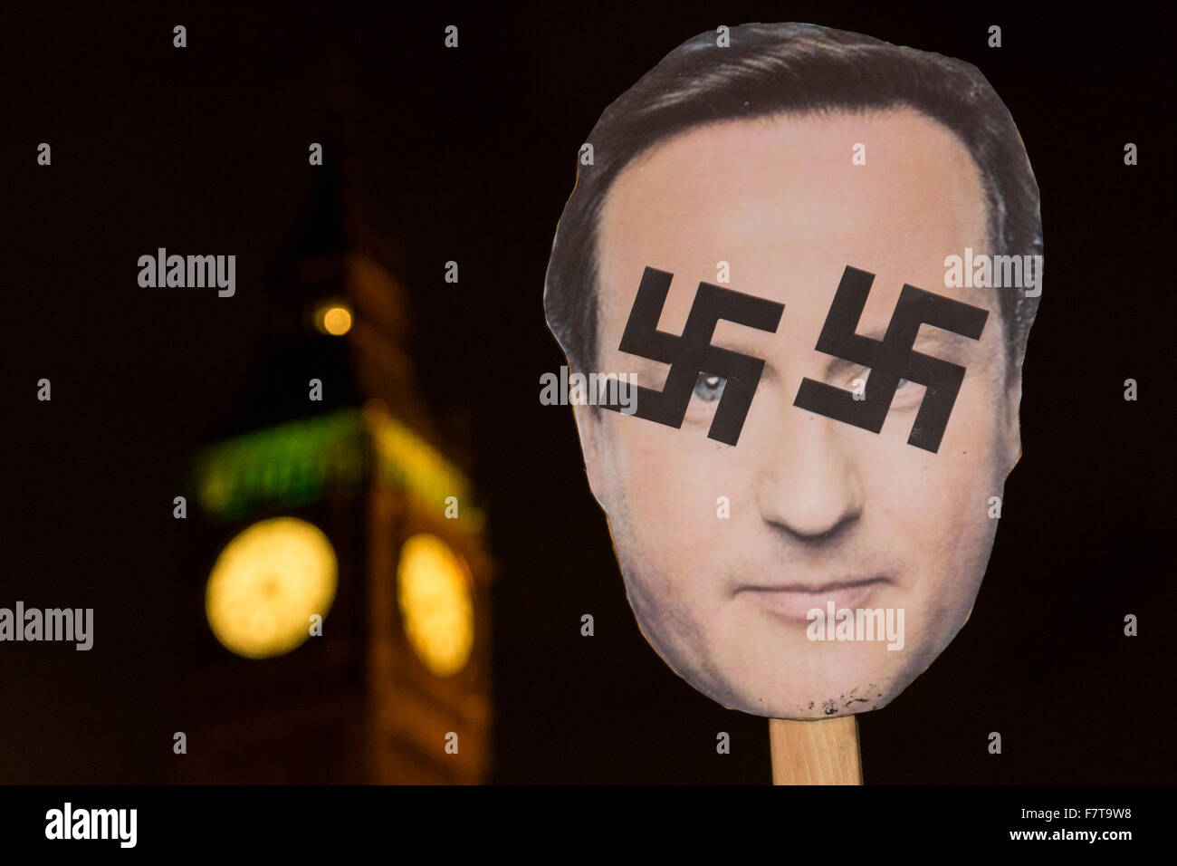 Londra, Regno Unito. Il 2 dicembre 2015. Un David Cameron maschera con svastiche è visibile nella parte anteriore del Big Ben. Non bombardare la Siria protesta al di fuori della sede del Parlamento. Centinaia di attivisti di pace attendere in piazza del Parlamento per il risultato della votazione in Assemblea di Commons. In serata la MPs IL REGNO UNITO autorizzato azione contro uno Stato islamico in Siria. Credito: Immagini vibranti/Alamy Live News Foto Stock