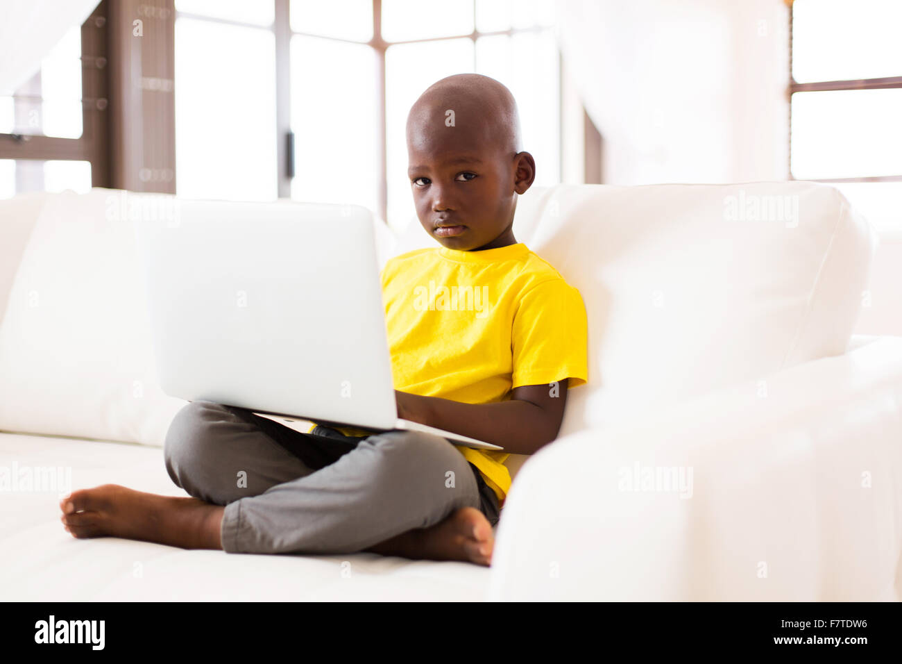 Adorabili poco African American Boy utilizzando computer portatile a casa Foto Stock