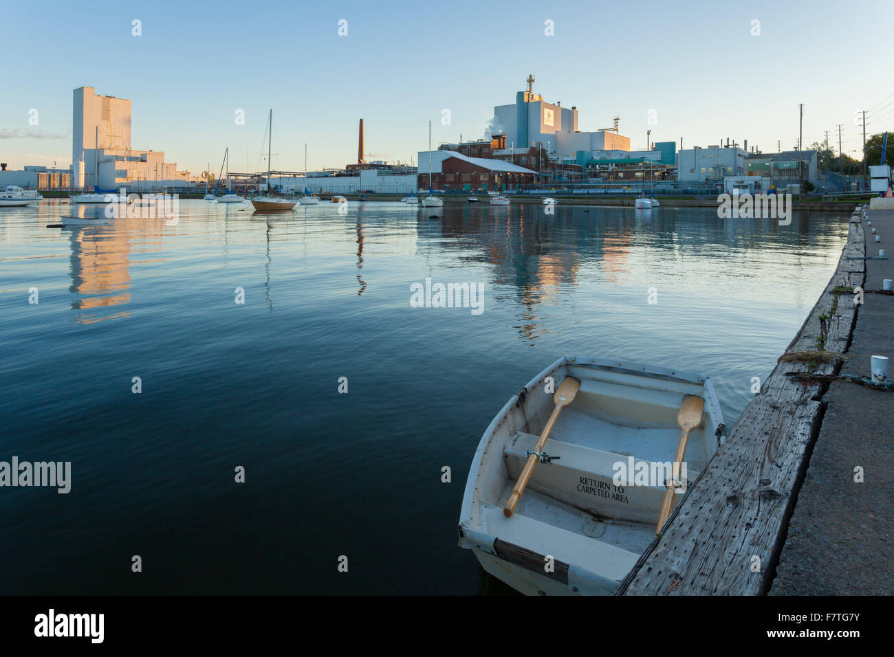 Un piccolo canotto con il carburante Cameco Manufacturing Inc. fabbrica in background al porto Hope Harbour. La porta di speranza, Ontario. Foto Stock