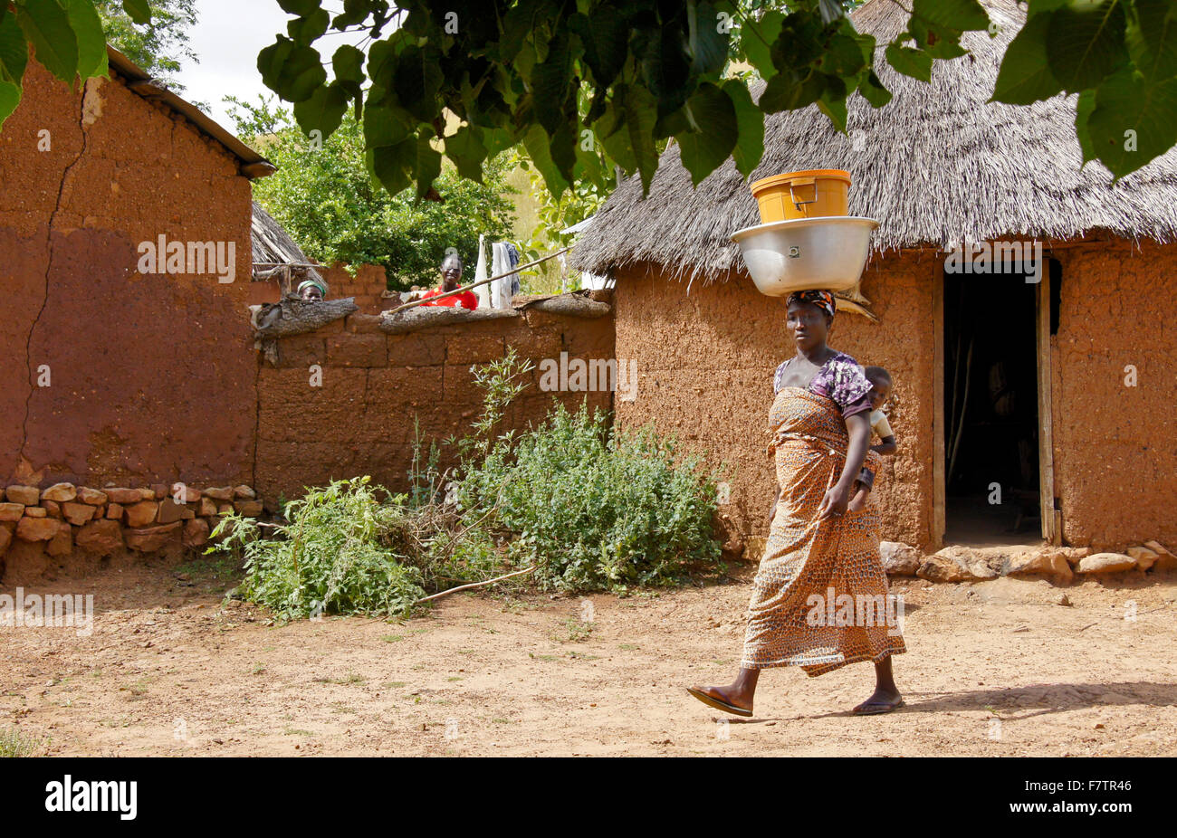 Kokomba donna tribale portando vasi sul capo e bambino sulla schiena, Bandjeli, Togo Foto Stock