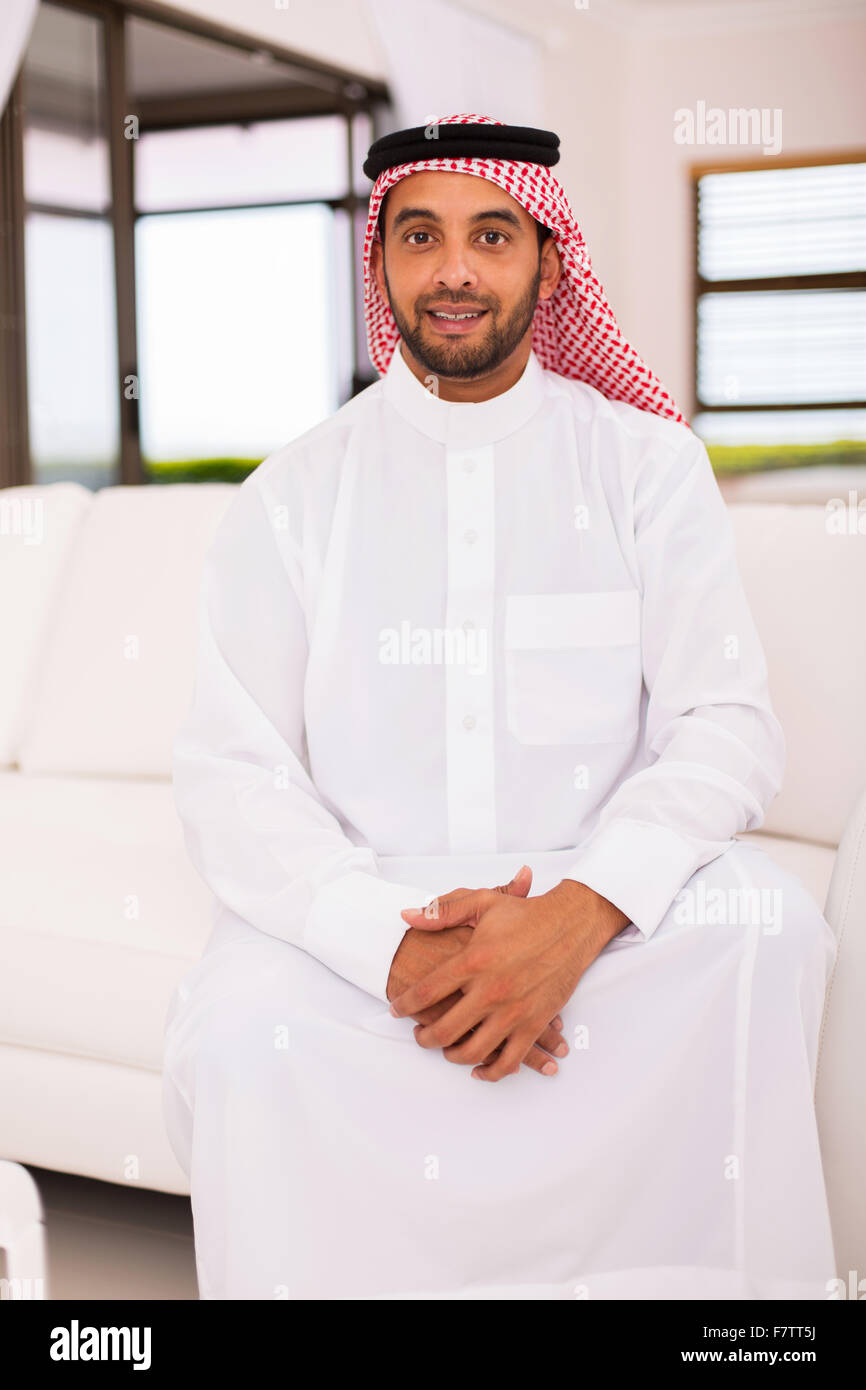 Bello Middle Eastern uomo seduto sul divano di casa Foto Stock