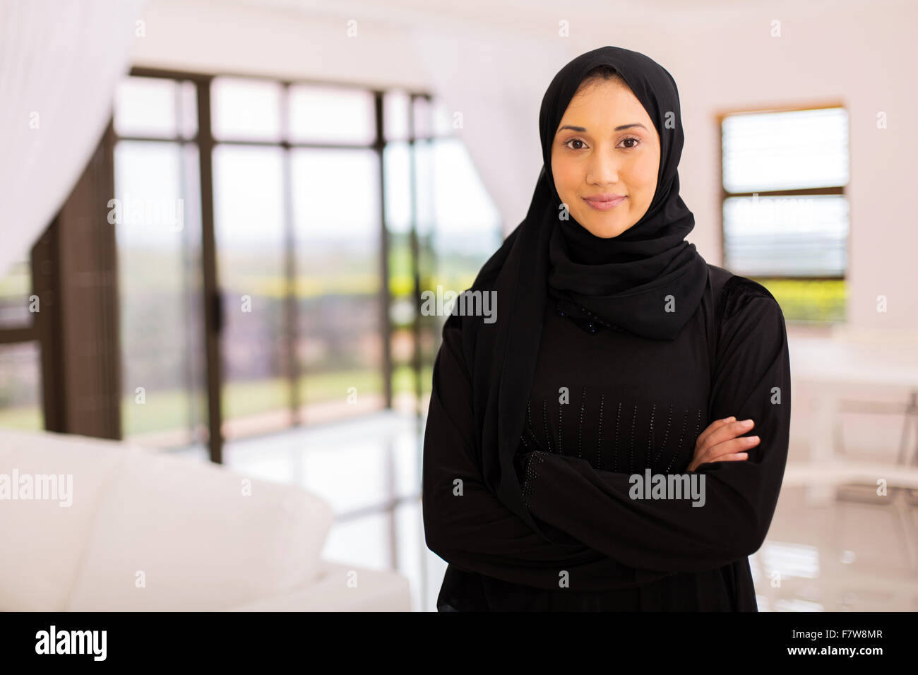 Ritratto di bella donna musulmana con le braccia incrociate a casa Foto Stock