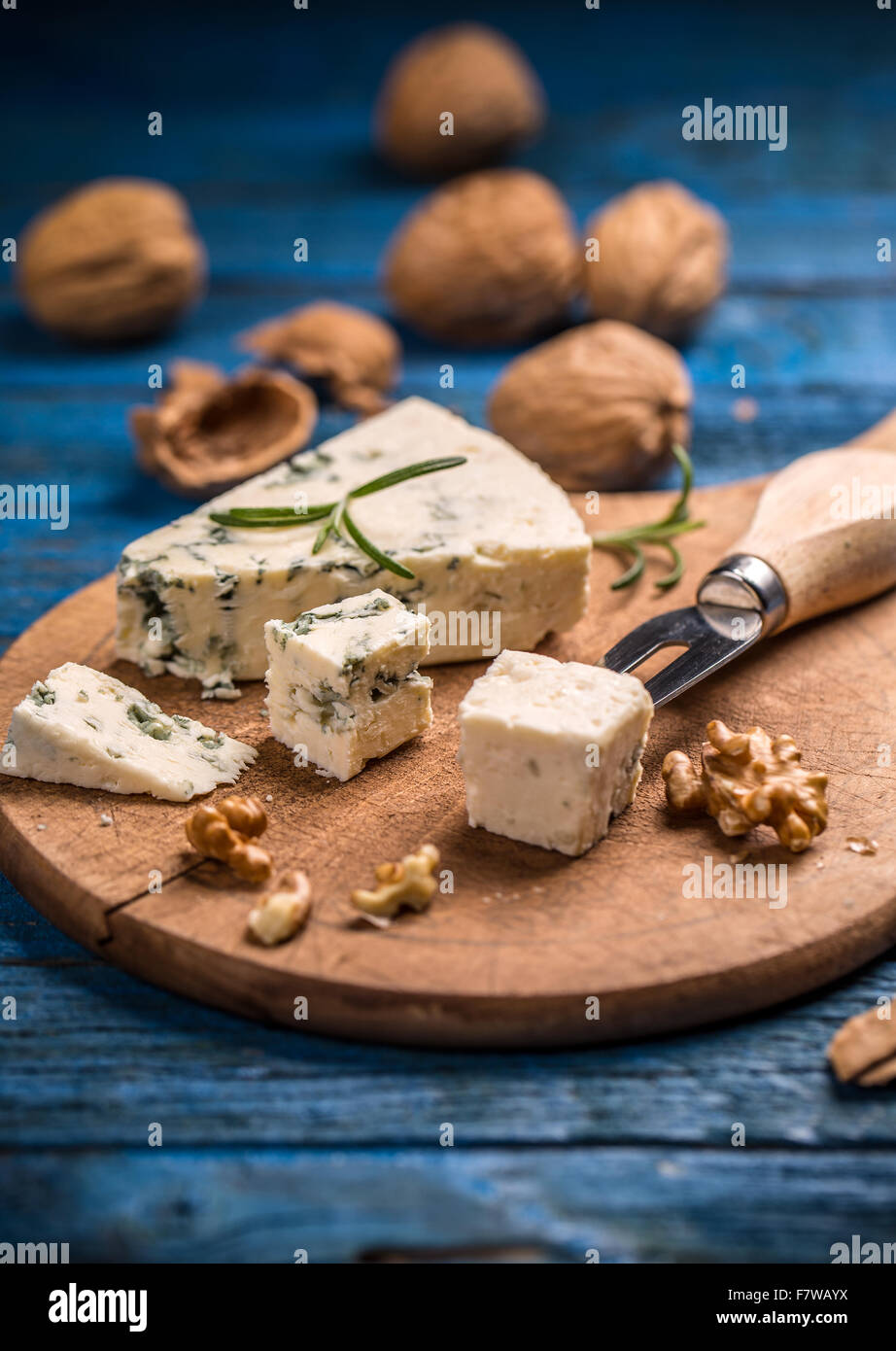 Formaggio blu con i dadi sul bordo di taglio Foto Stock