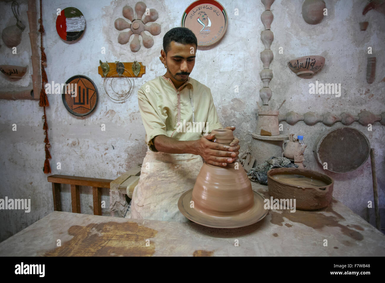 Uomo di argilla di stampaggio a mano, Emirates Heritage Village, Abu Dhabi, Emirati Arabi Uniti Foto Stock